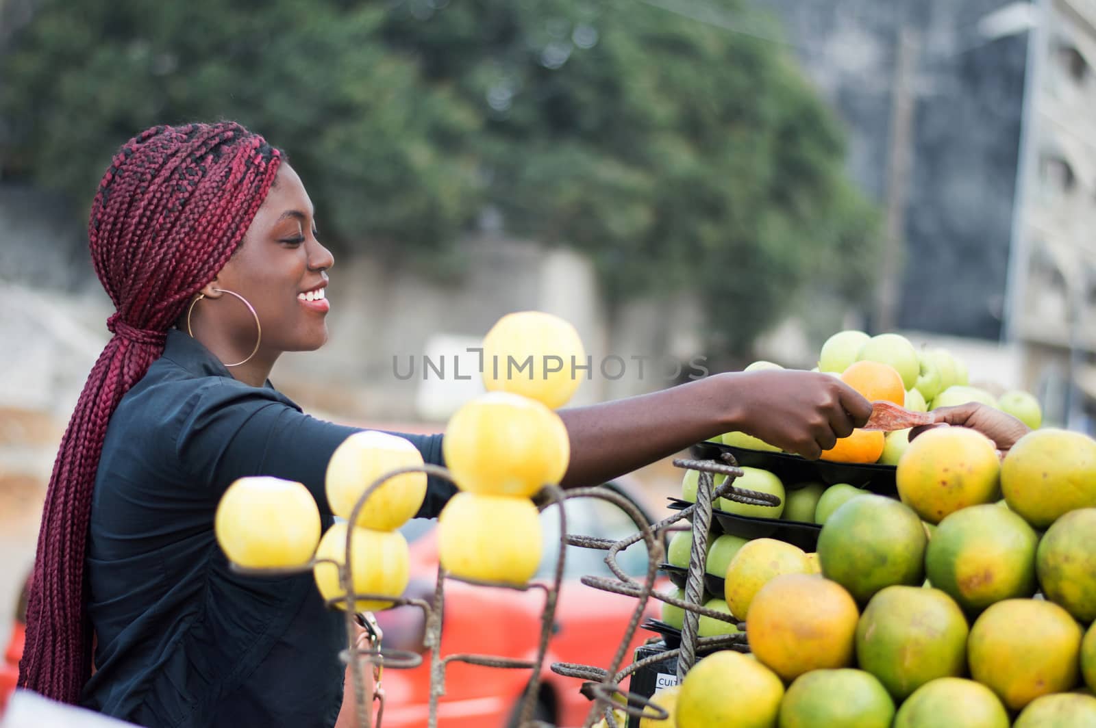 smiling young woman takes her money in the hand of the fruit seller .