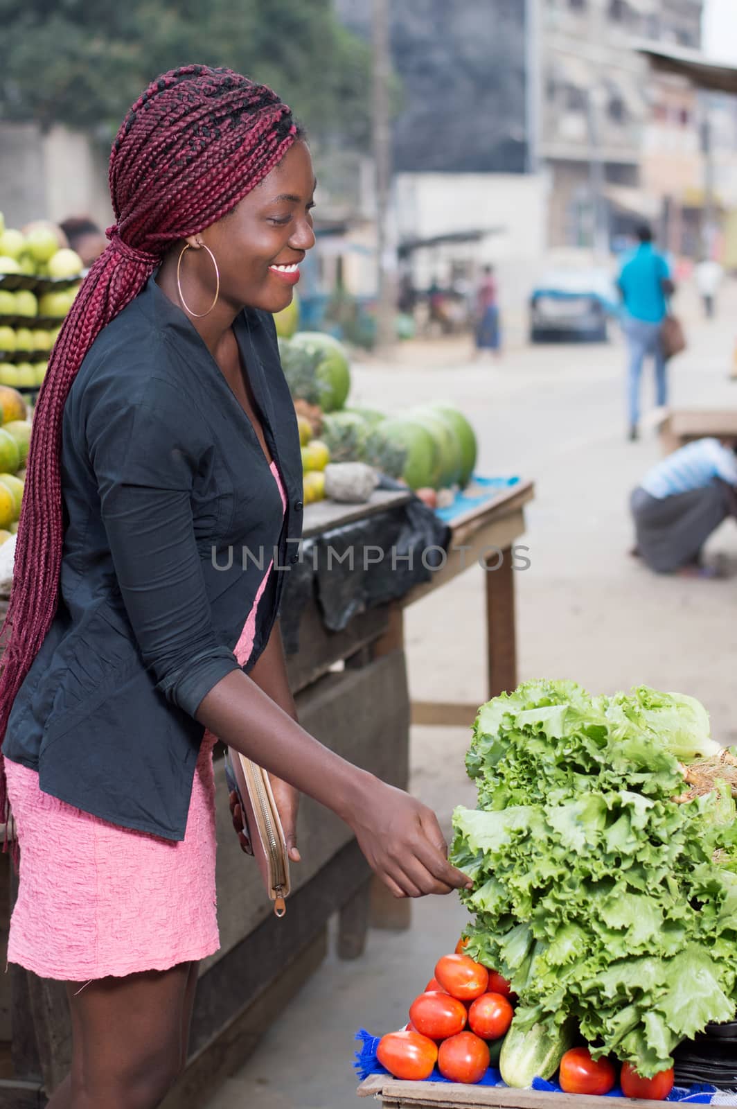 smiling young woman asks the price of a kilogram of vegetables.