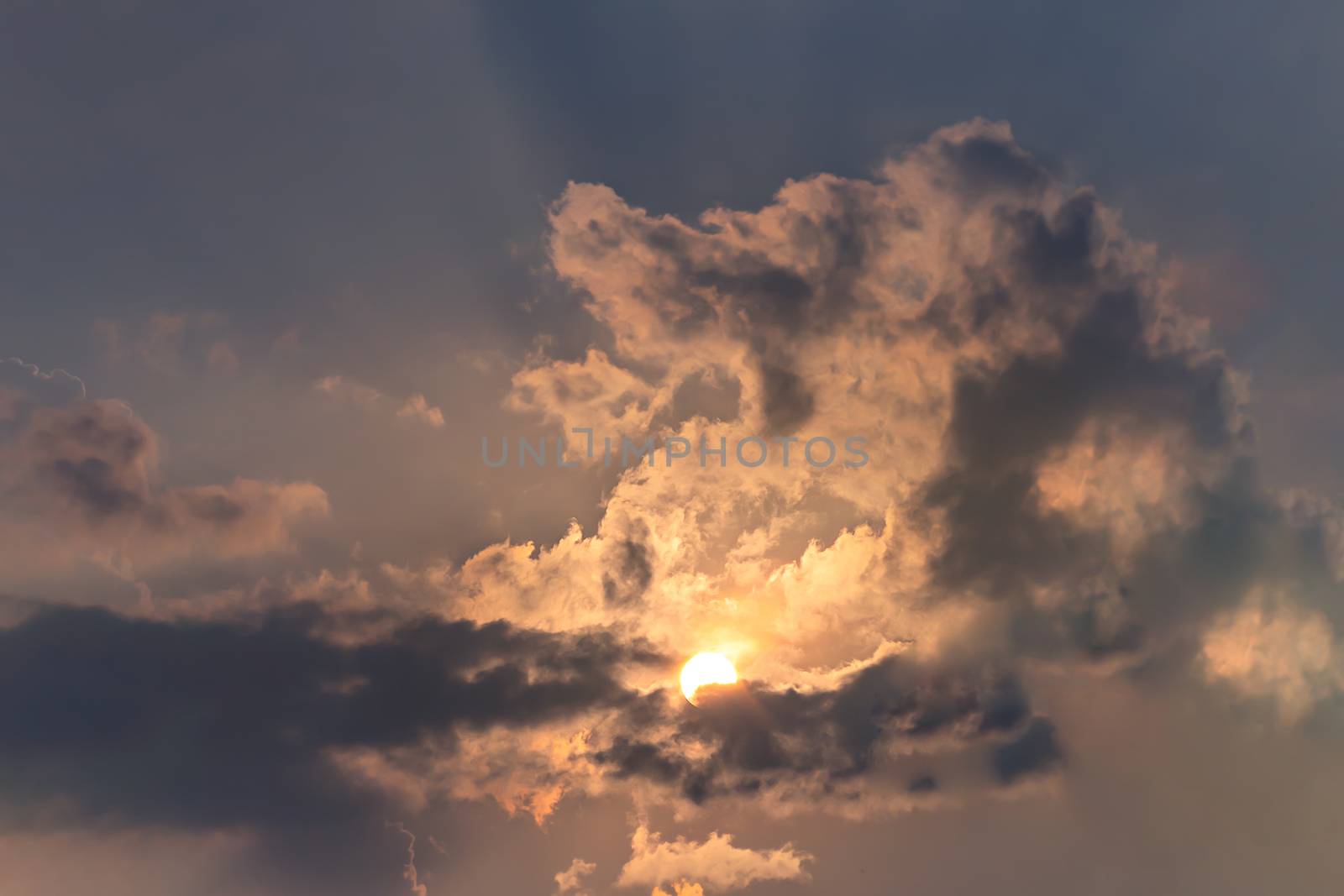 Beautiful nature rays of bright sun peep out from behind the clouds on sky