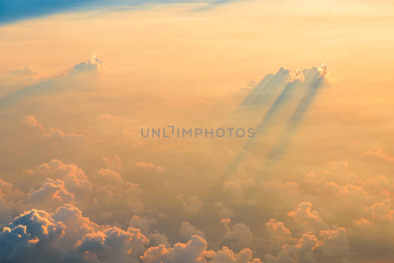 Beautiful aerial view of clouds at sunset, some clouds projecting dramatic shadows. View from airplane.