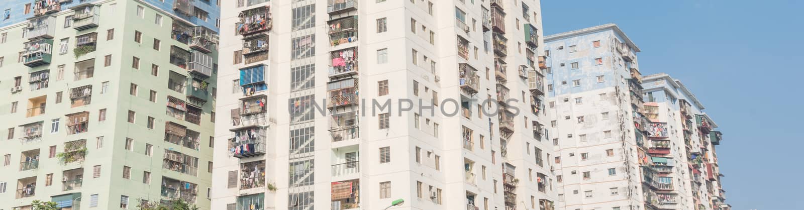 Panoramic lookup typical condos with hanging clothes over blue sky in Hanoi, Vietnam by trongnguyen
