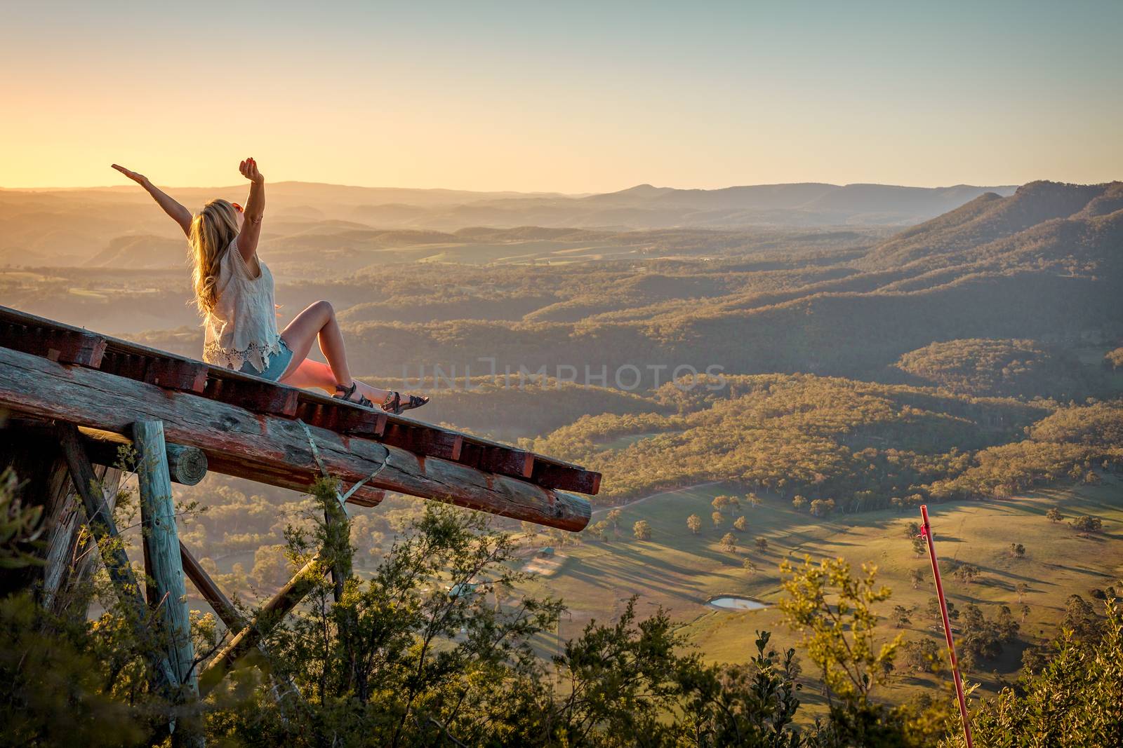 Freedom loving woman feeling exhilaration on ramp high above the valley by lovleah