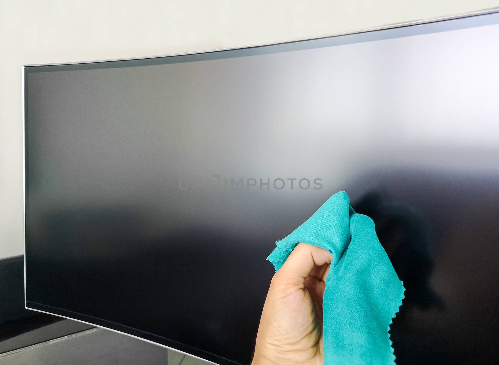 cleaning pc monitor an hand hold a rag .