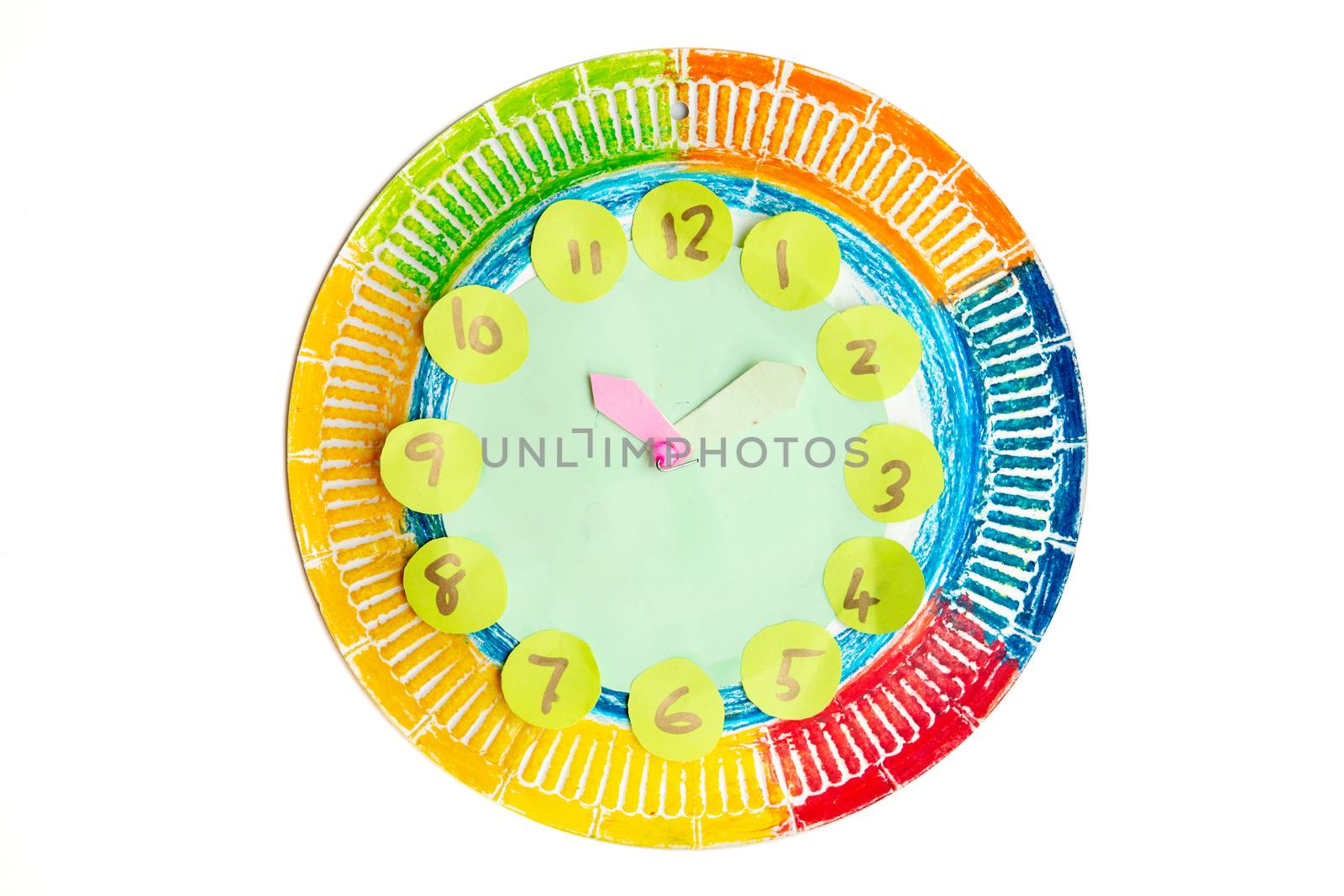 Colorful child handwork clock pointing at ten past two, isolated on white background