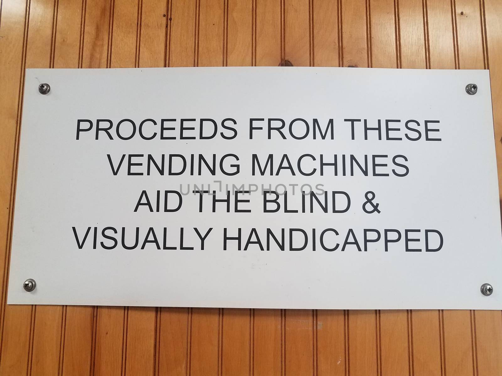 proceeds from vending machines aid the blind and visually handicapped sign on wood wall