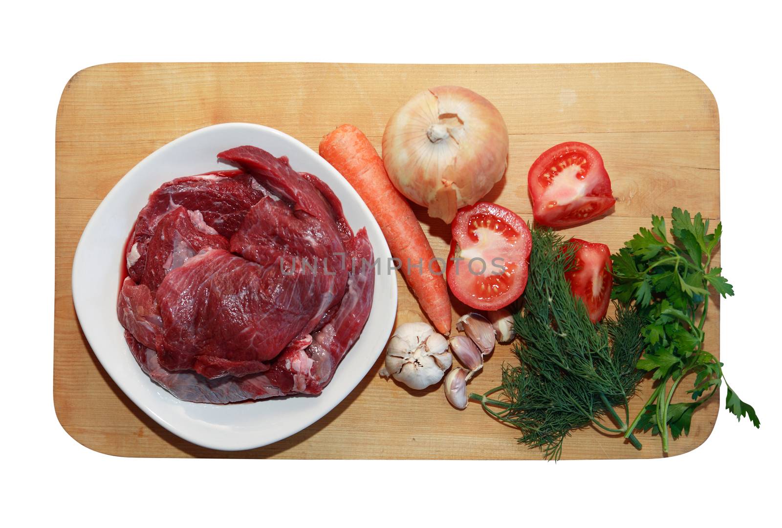 Portion of raw beef meat for cooking near vegetables