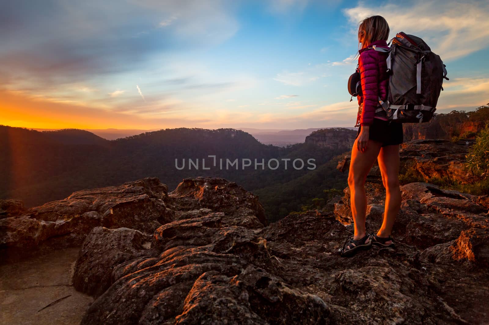Female hiker  on bushwalk in upper Blue Mountains, watching a sunset from the peak