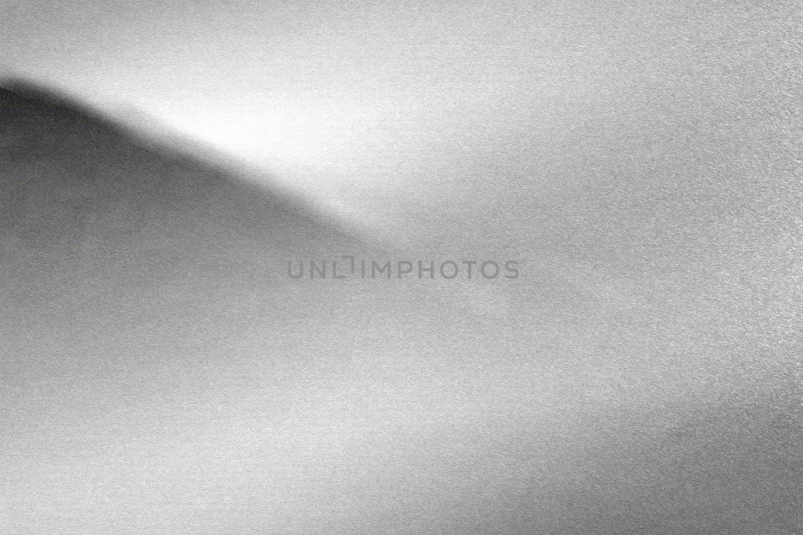 Light shining on rough silver metal wall, abstract texture background