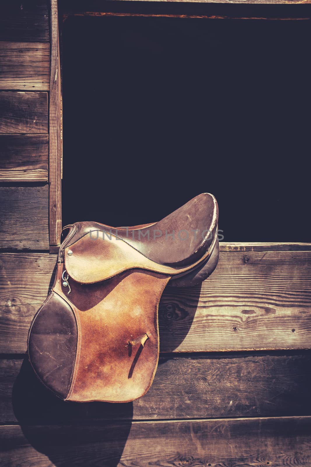 Americana Image Of A Horse Saddle Hanging In A Ranch Stable Door With Copy Space