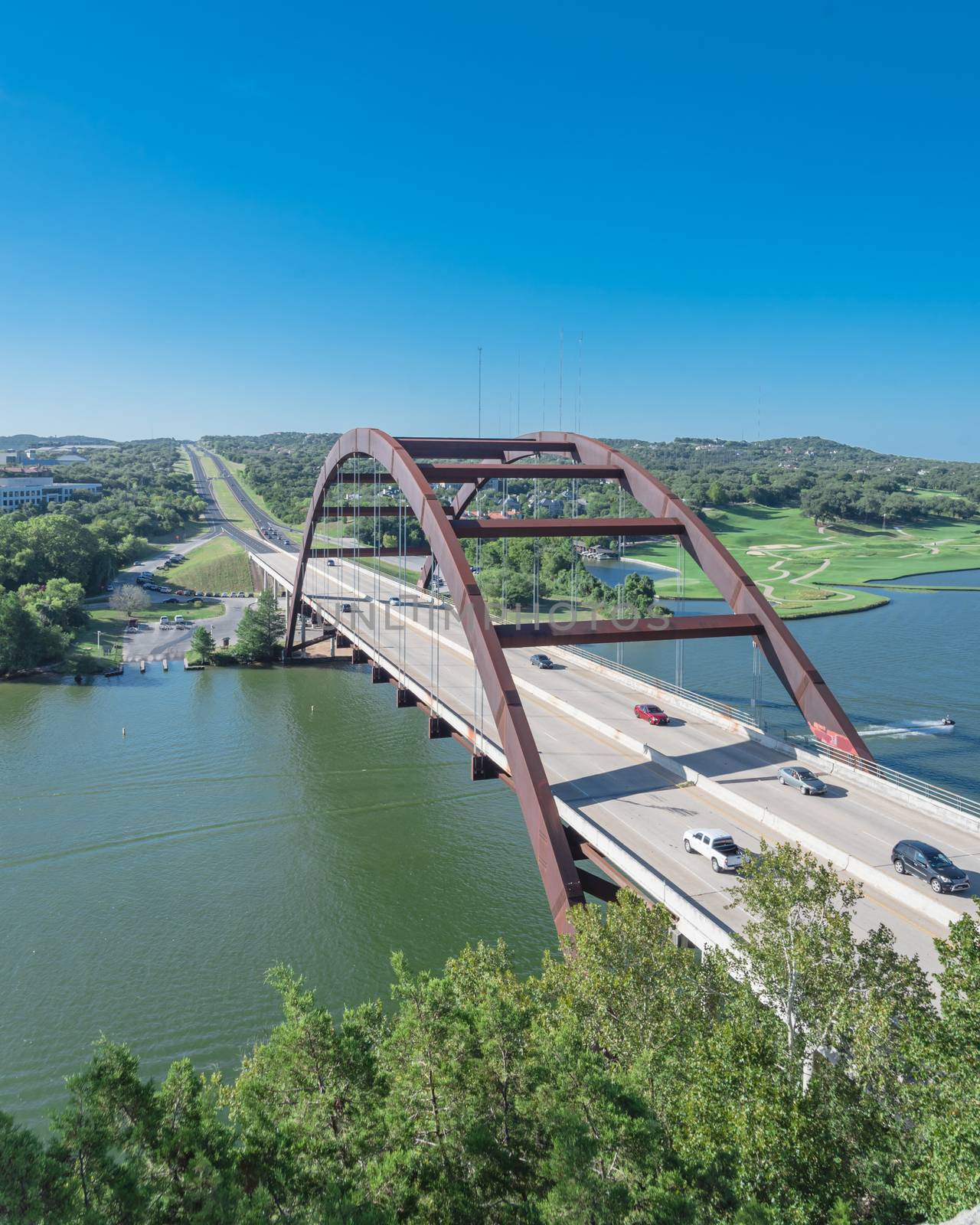 Elevated view of Pennybacker Bridge or 360 Bridge with car traffic at daytime. A landmark in Austin, Texas, USA. Top of Town Lake, Colorado River and Hill Country green landscape