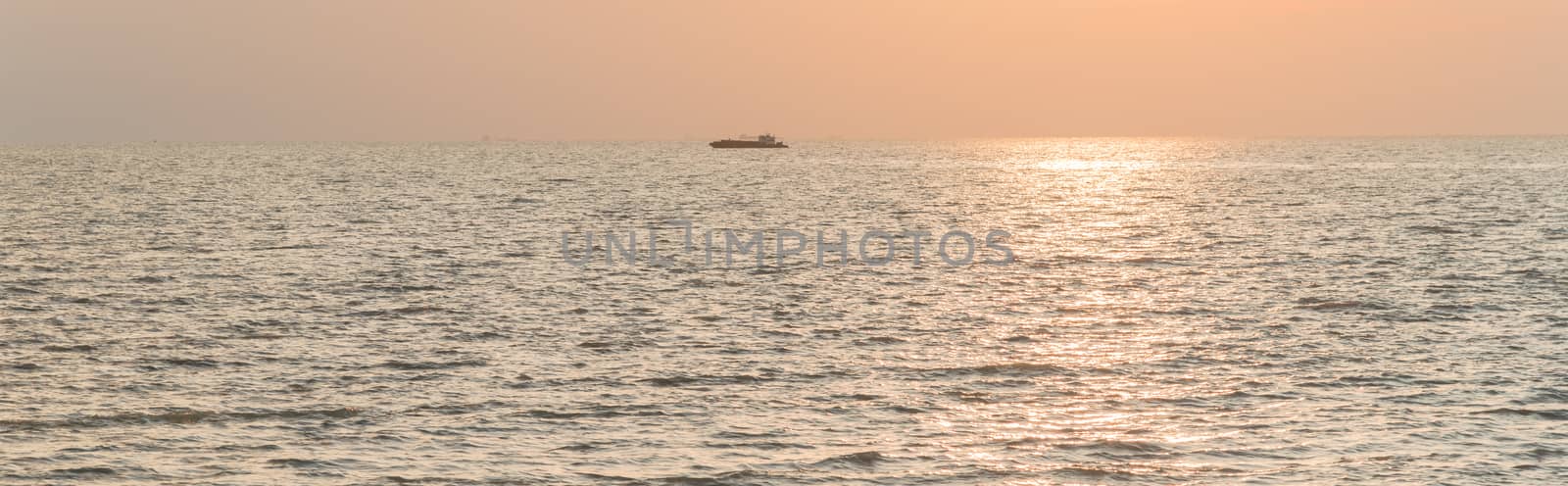 Panorama view scenery sunset on the beach of Melaka, Malaysia. Shipping boat and cruise can seen in the distance