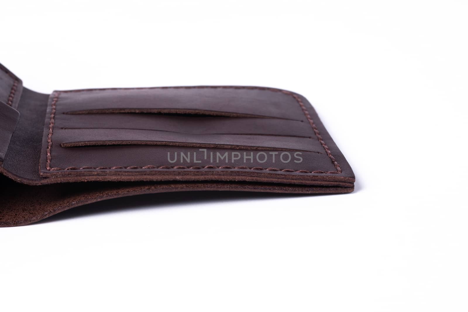 A part of brown handmade leather man wallet isolated on white background. Wallet is open. Stock photo of luxury businessman accessories.