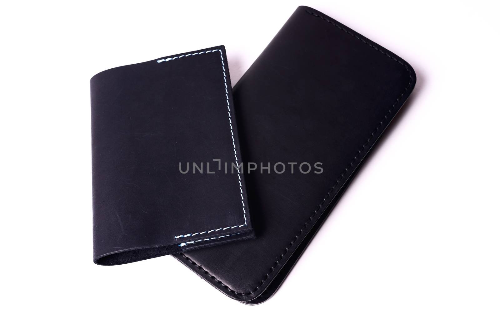 Black handmade leather man wallet and passport cover isolated on white background. Purse and cover are closed. Stock photo of luxury businessman accessories.