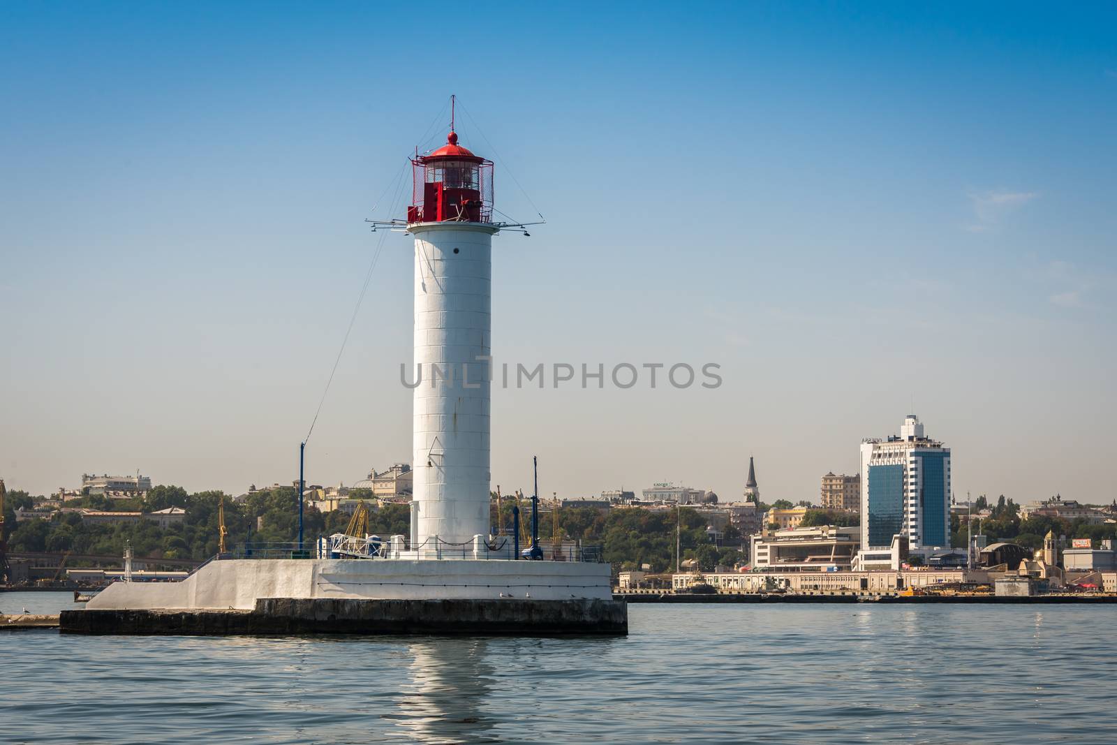 Lighthouse at the entrance to the harbor of the Odessa port, the sea gates of Ukraine in a sunny summer day