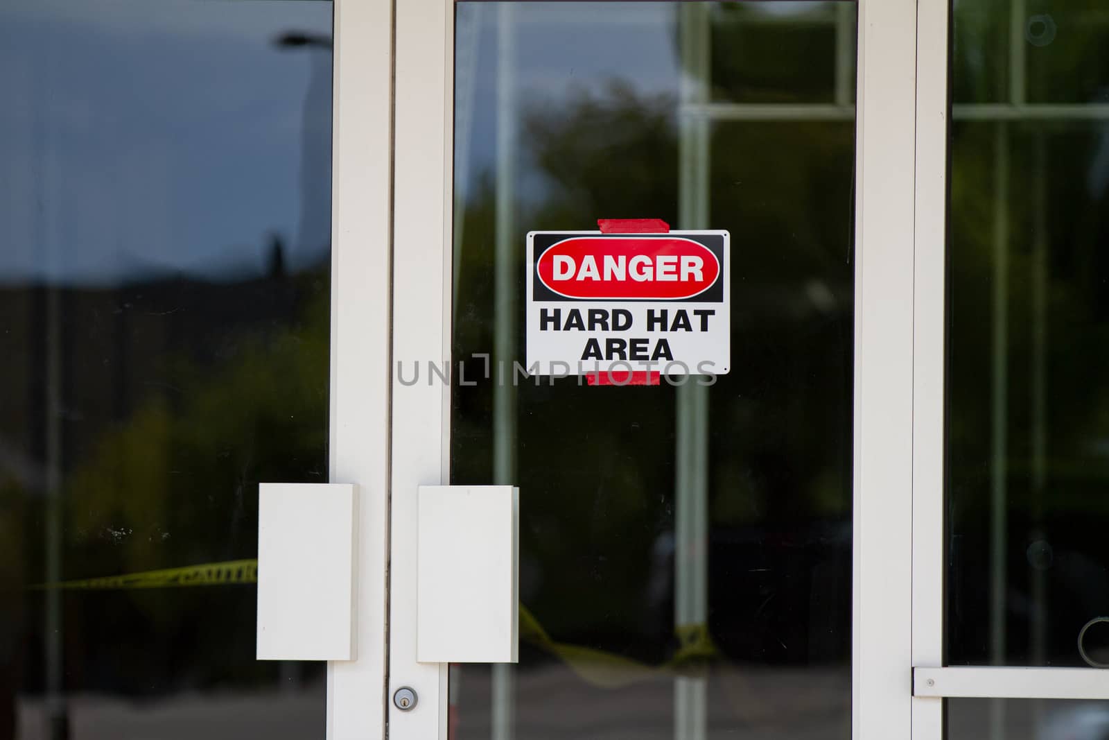 Sign on a glass door requiring hard hats for safety