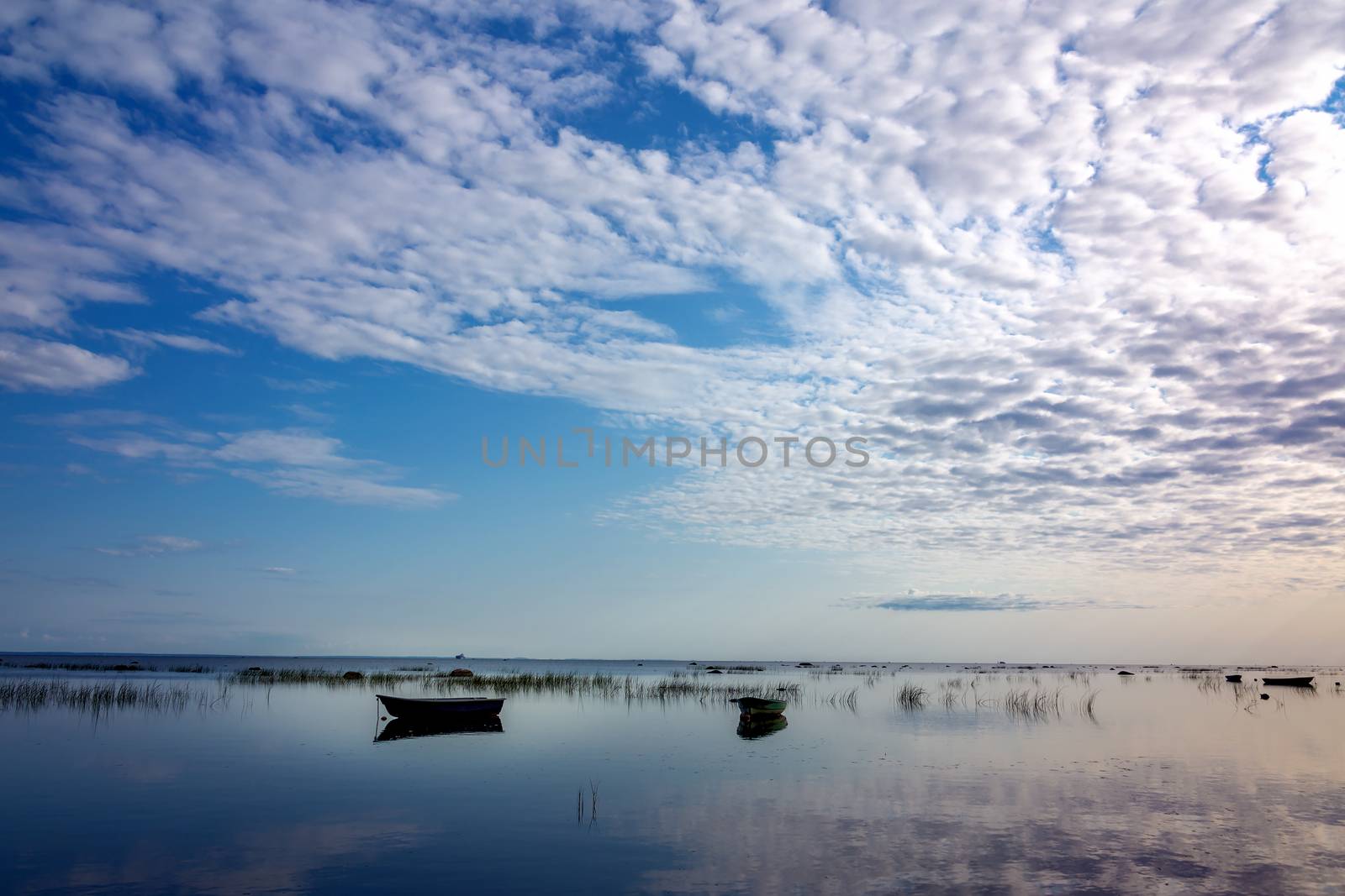 Fishing boat in clear lake at sunset. Scenic view. by Anelik