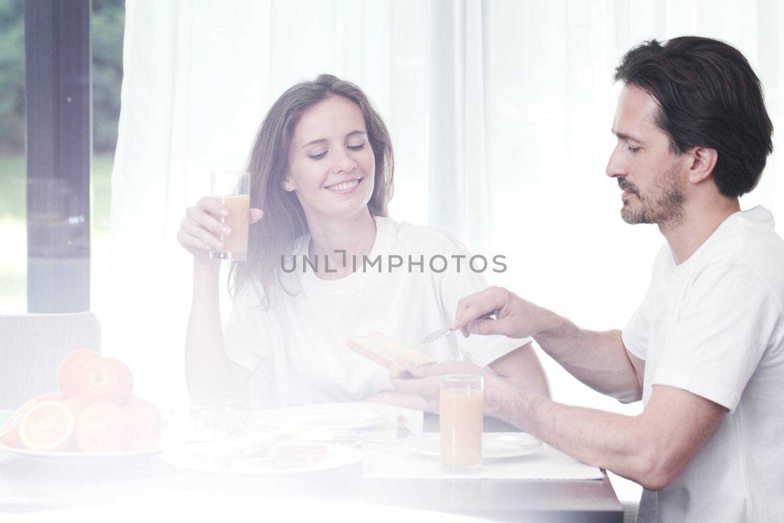 Happy couple having breakfast together at home
