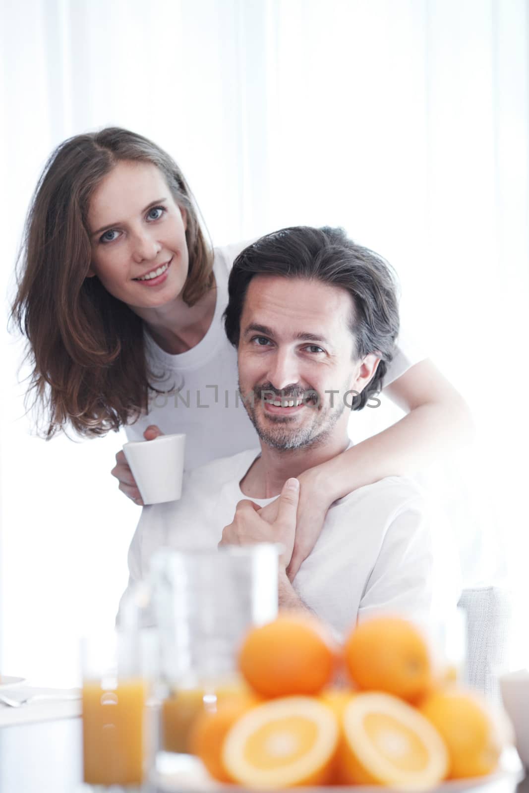 Couple having breakfast together at home , oranges and juice on the table