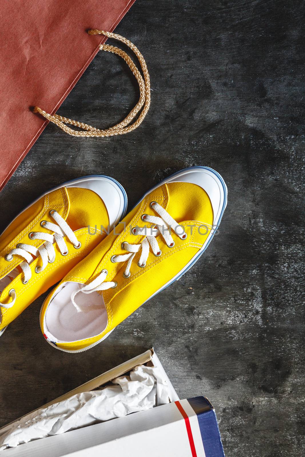 New yellow sneakers, box and package from the store on a dark co by Tanacha