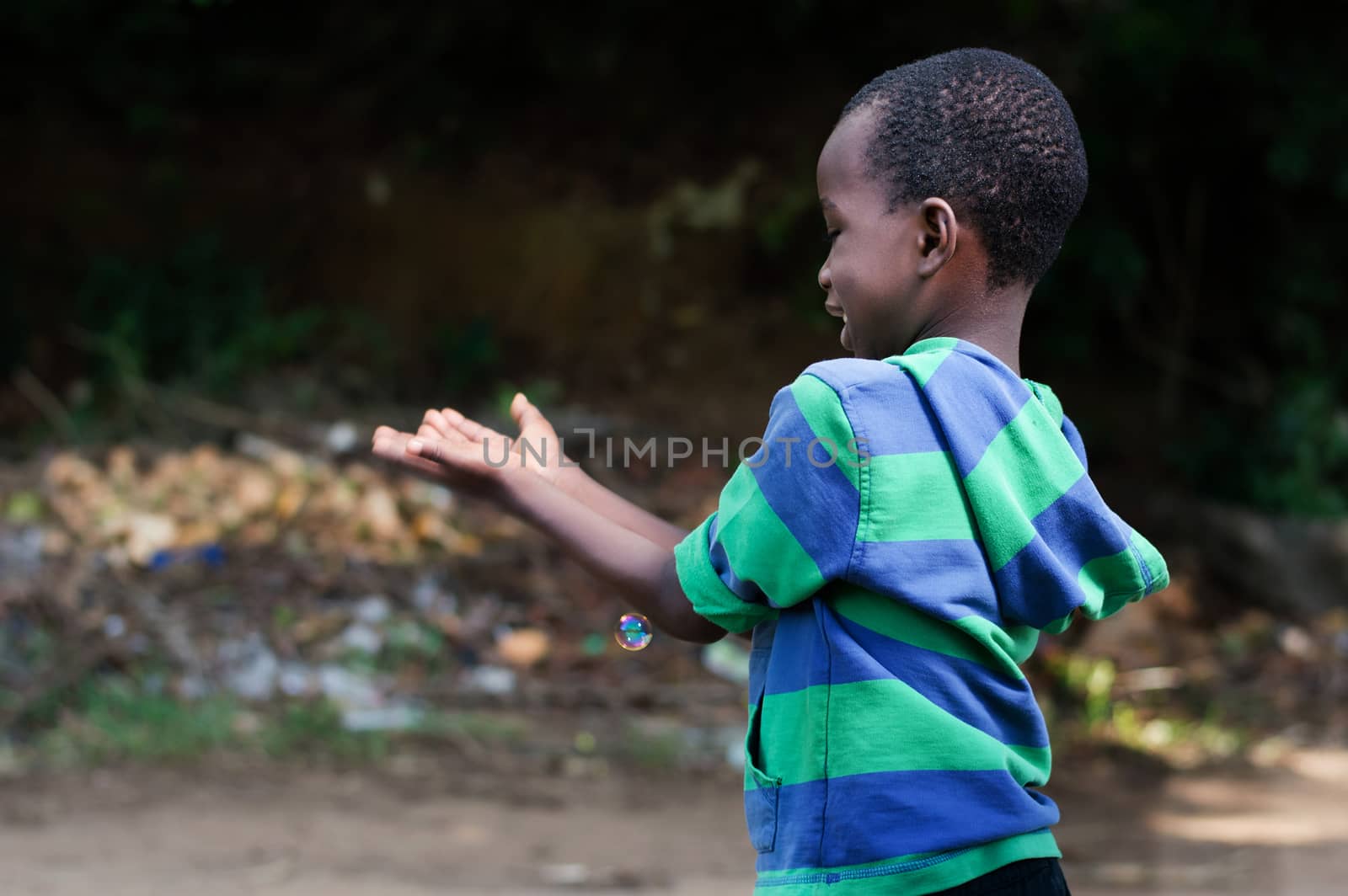 little boy wants to catch the bubbles blown by his mother.