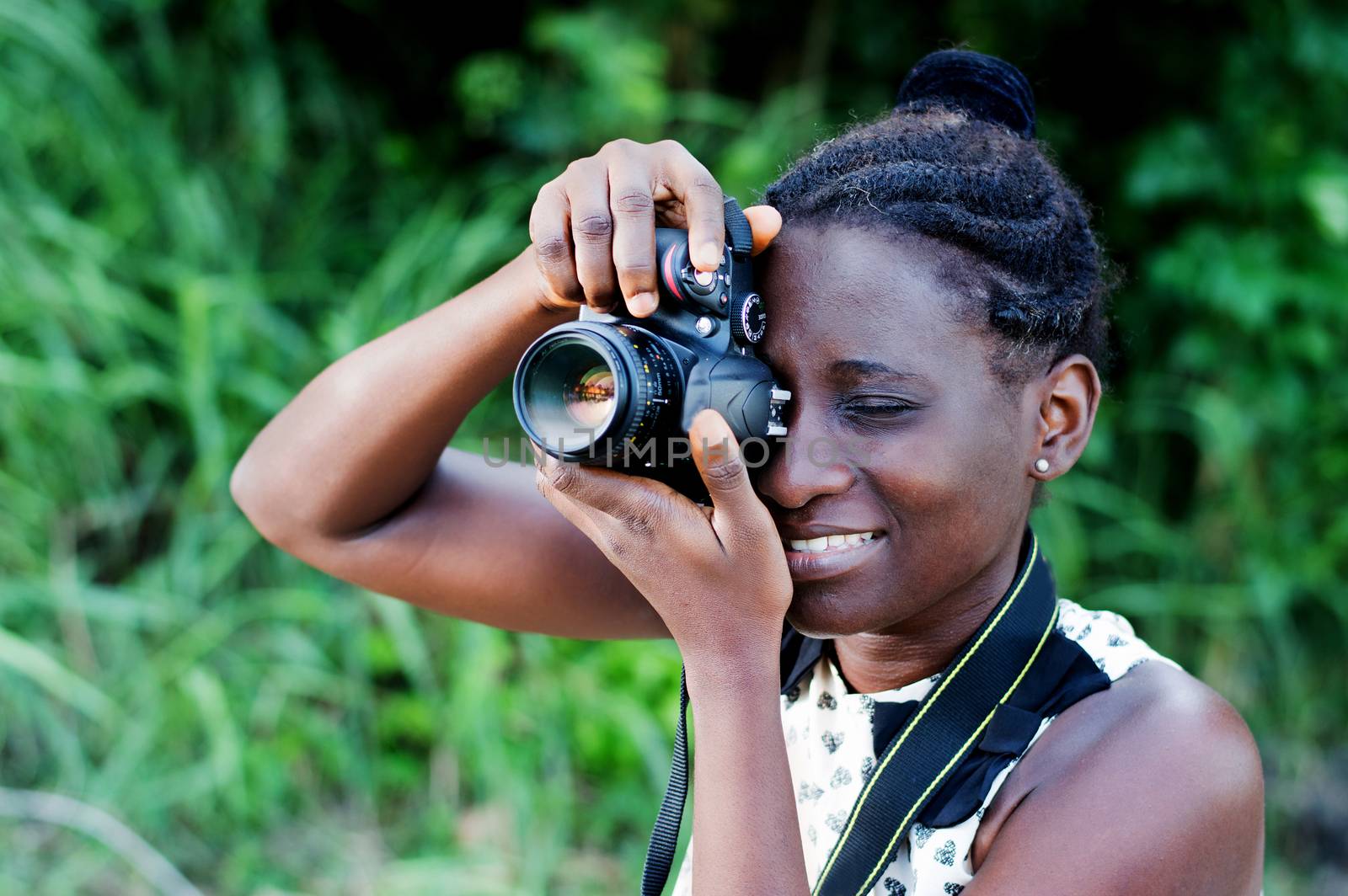 Travel, tourism and hobby. Young woman photographer taking pictures in the bush.