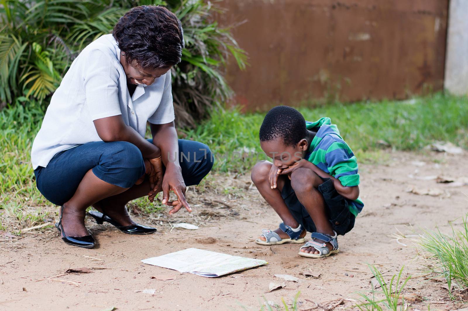 In travel and tourism, a young mother reads a map with her child in the country.