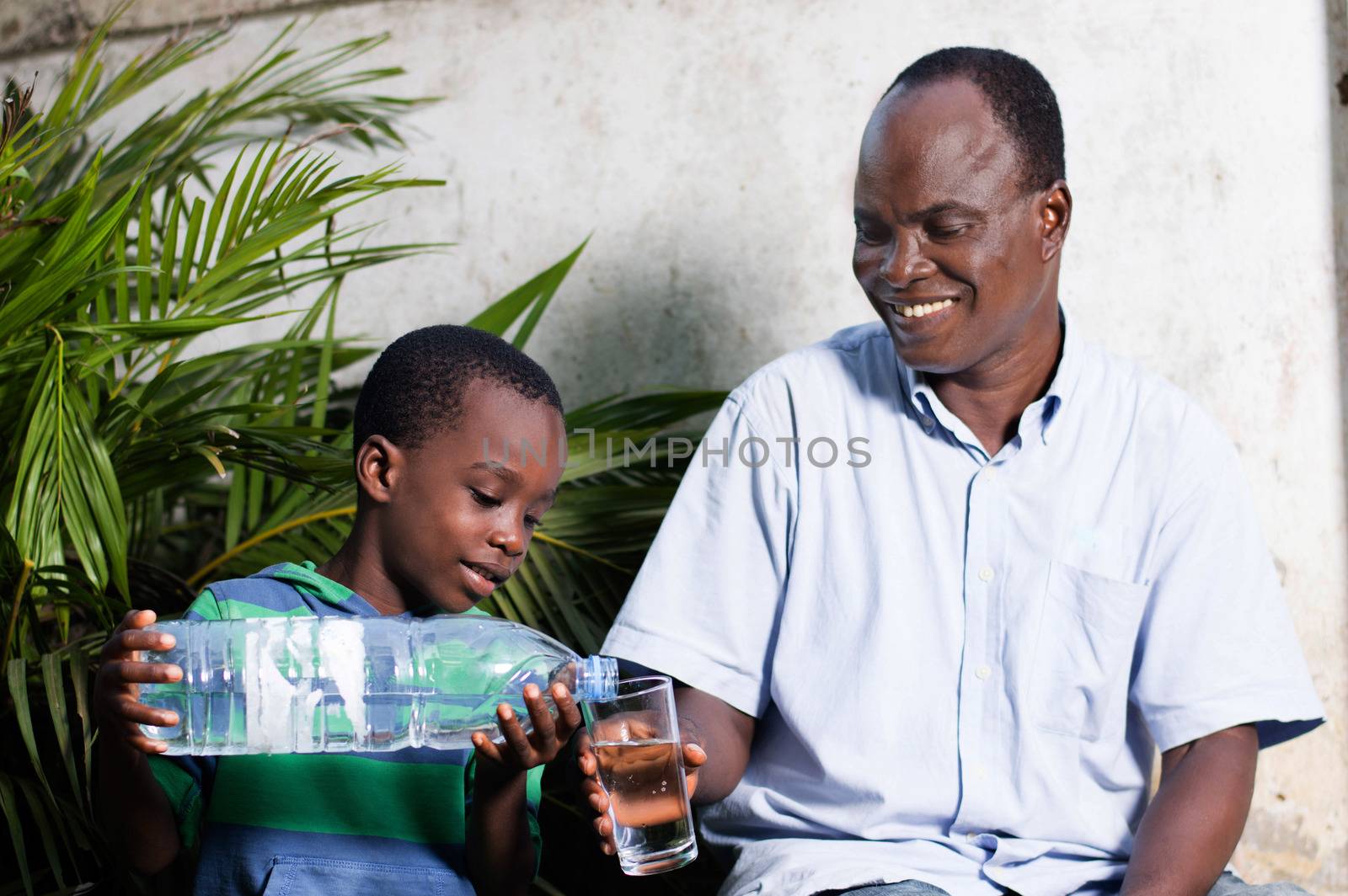 child out of the water in a glass to his smiling father
