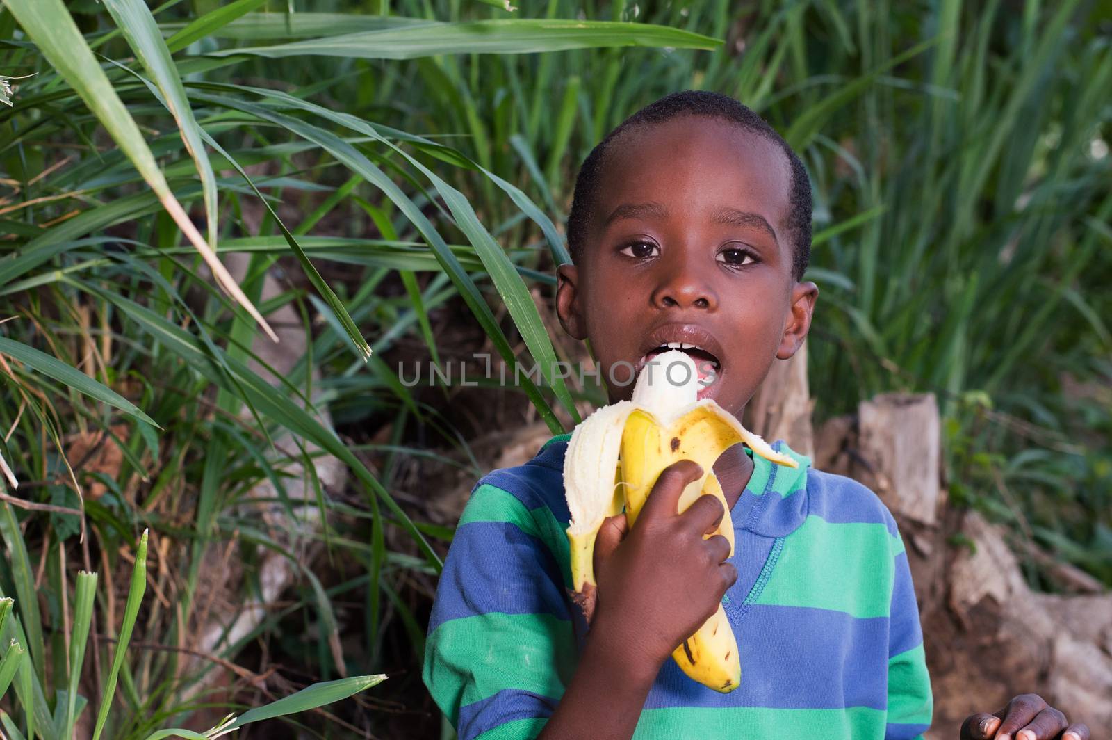 happy little boy eating a banana.