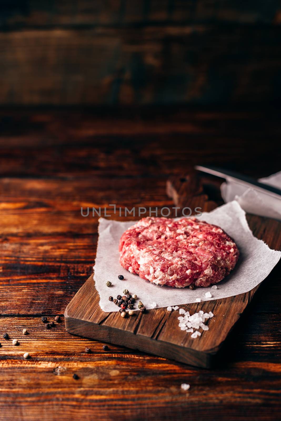 Raw Pork Patty with Spices on Cutting Board for Burger. Vertical Orientation and Copy Space.