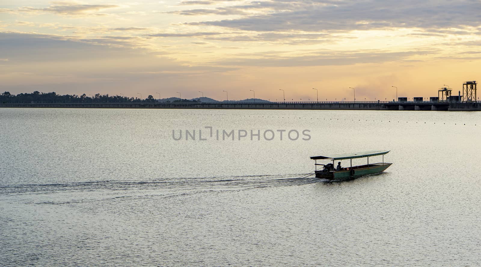 Passenger boats across the side of the dam. Evening atmosphere along the water in the dam. Sailing boat to transport people across the canal In the water storage dam