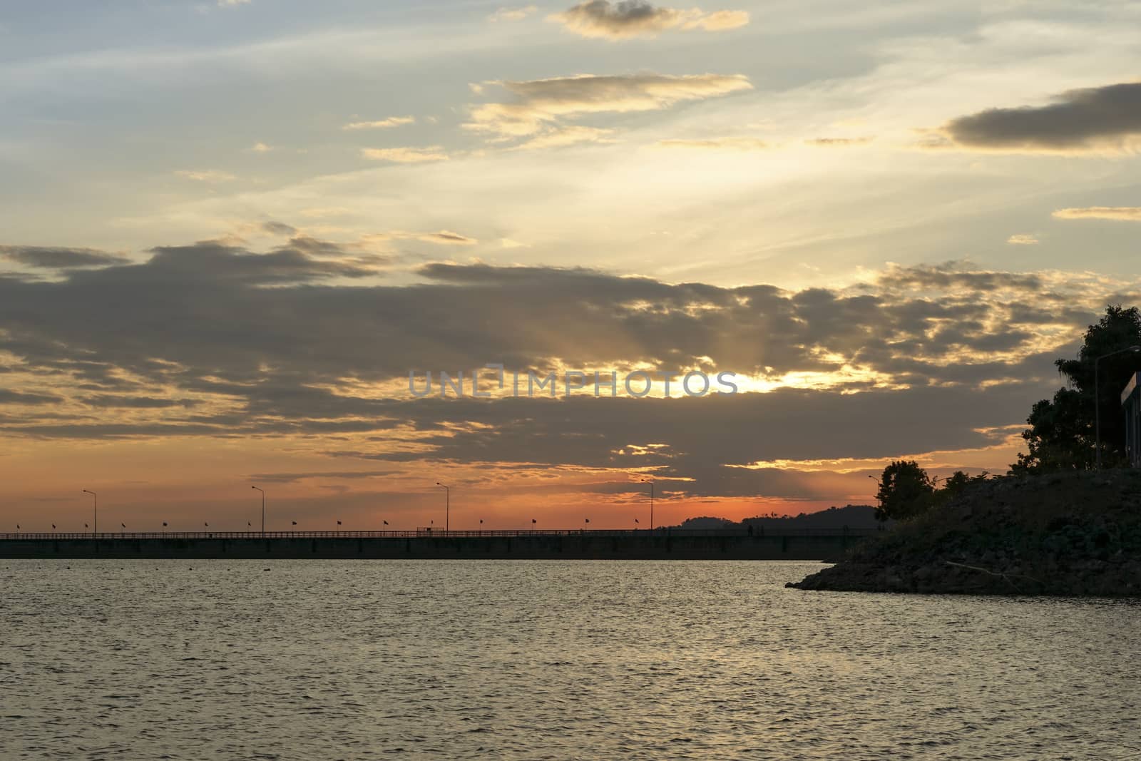 Sunset at the dam collecting water. Orange evening sky