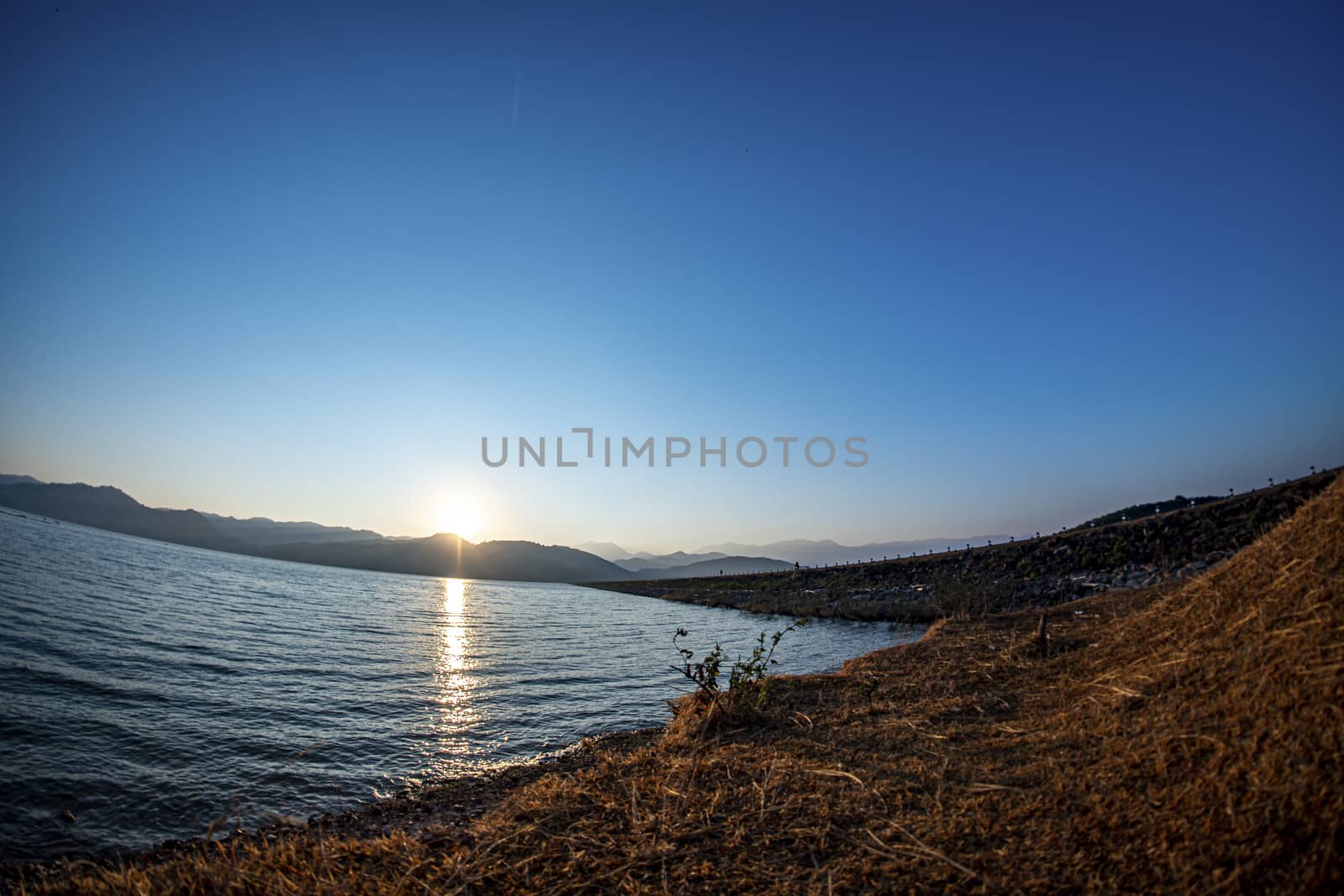 Sunrise at the reservoir, clear blue sky, wide angle from Lens Fisheye, March 9, 2019, Khlong Din Daeng Reservoir, Nakhon Si Thammarat, Thailand