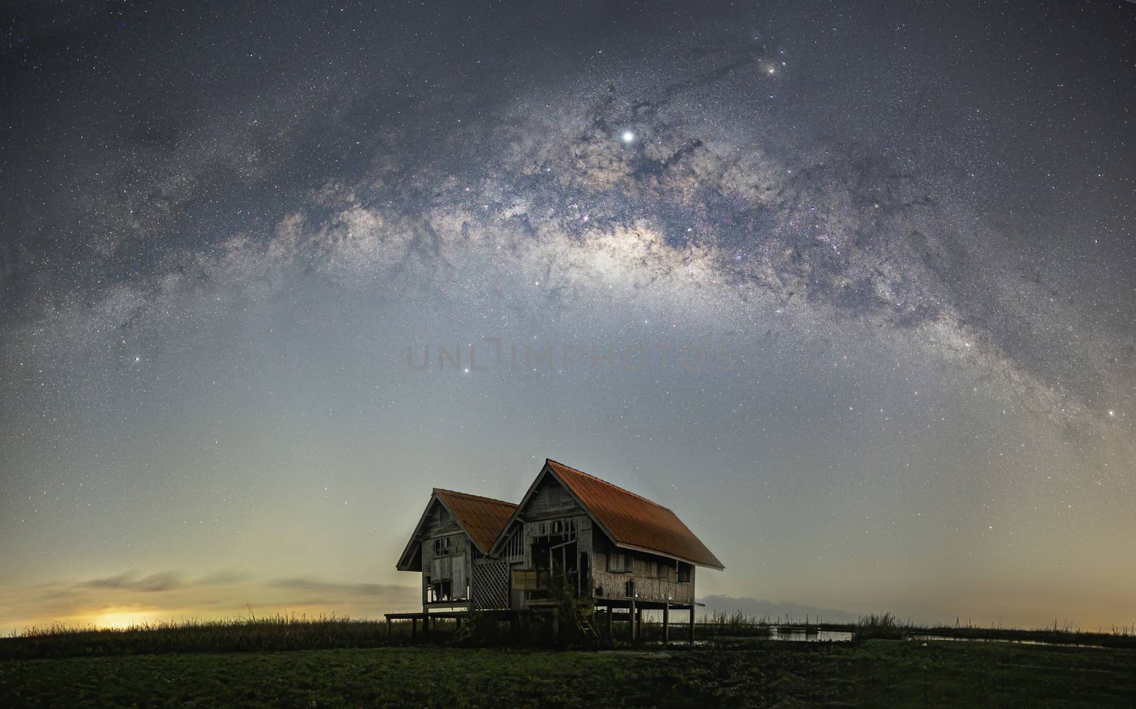 Milky Way panorama, old abandoned house, red roof on open field