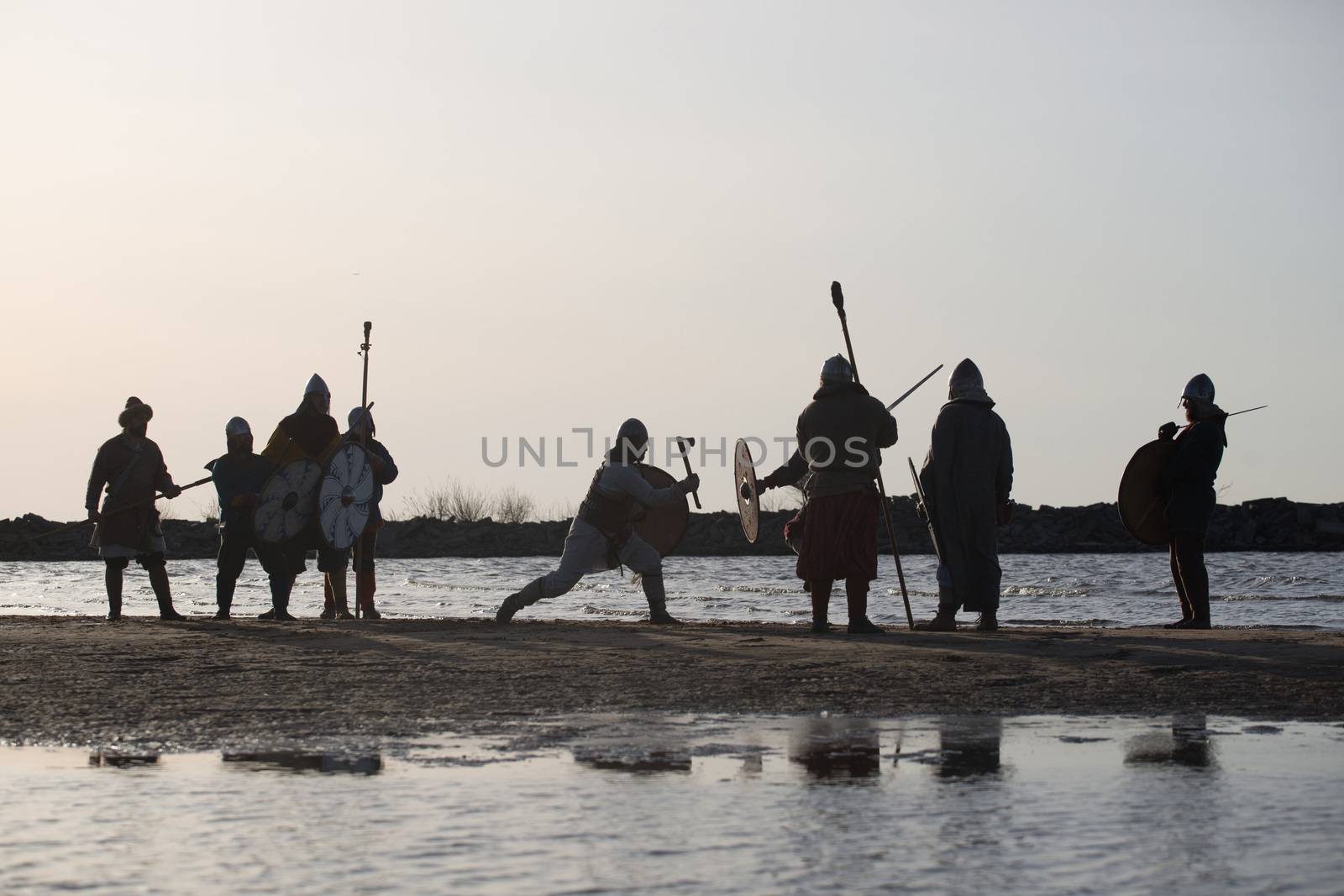 Slavic warriors reenactors with wearpons and shields training fighting outdoors at seaside