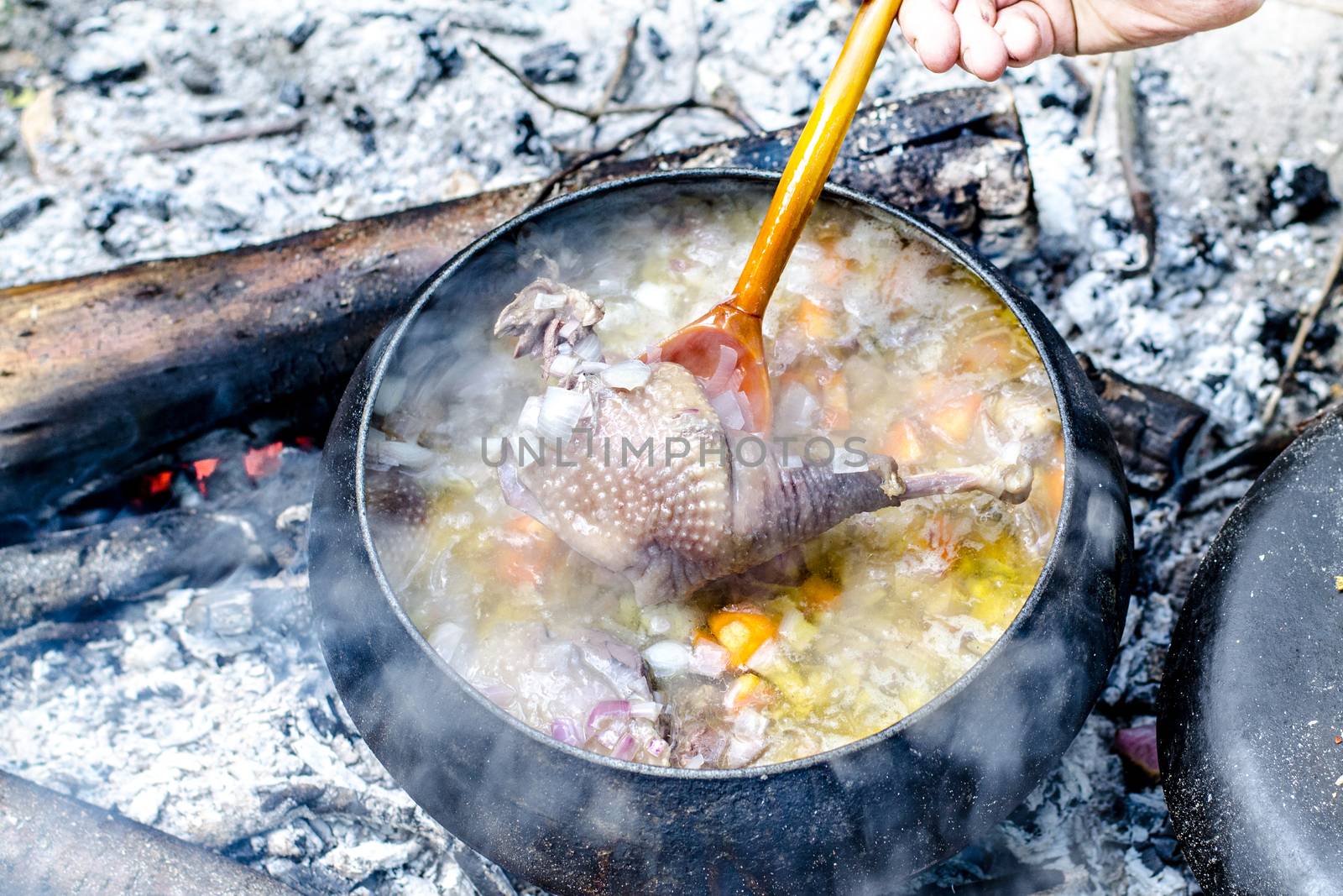 Soup is cooked in a tourist pot on the fire.