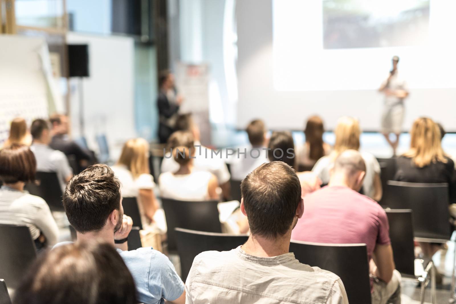 I have a question. Group of business people in conference hall. Businessman in audience standing and asking question to speeker. Conference and Presentation. Business and Entrepreneurship.