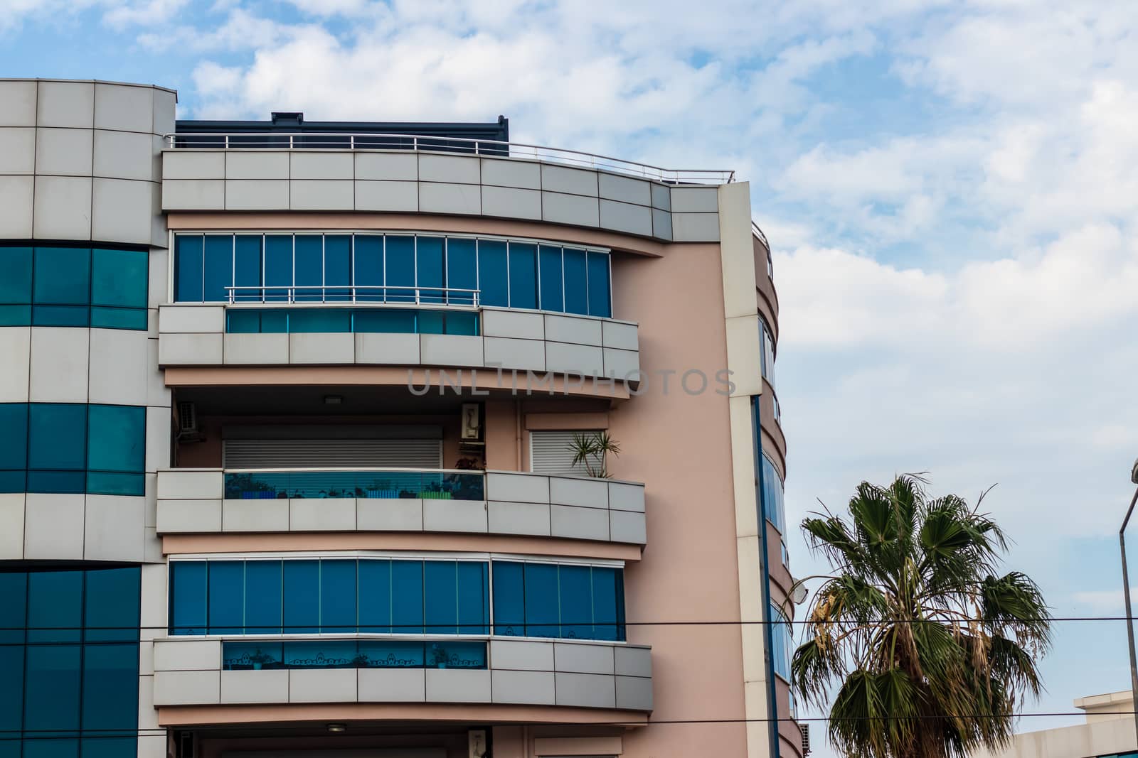 a corner shoot from an modern building with balcony - sky landscape as background. photo has taken at izmir/turkey.