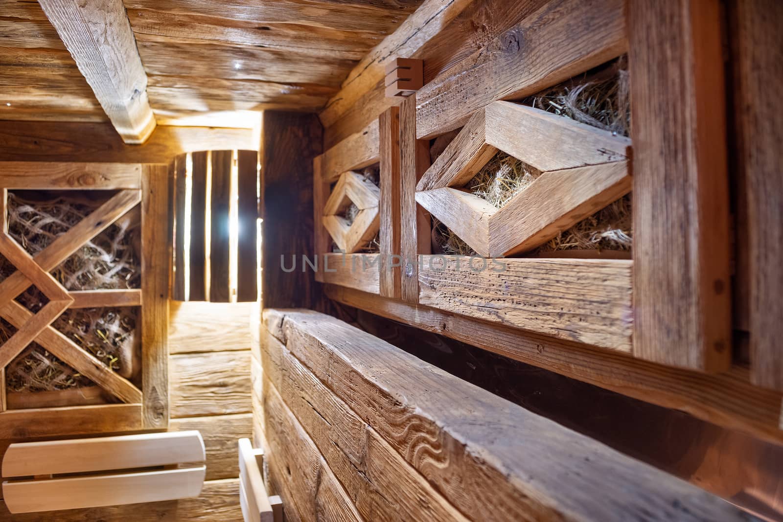 Handmade bath in the spa complex. The bath is trimmed with planks and hay.