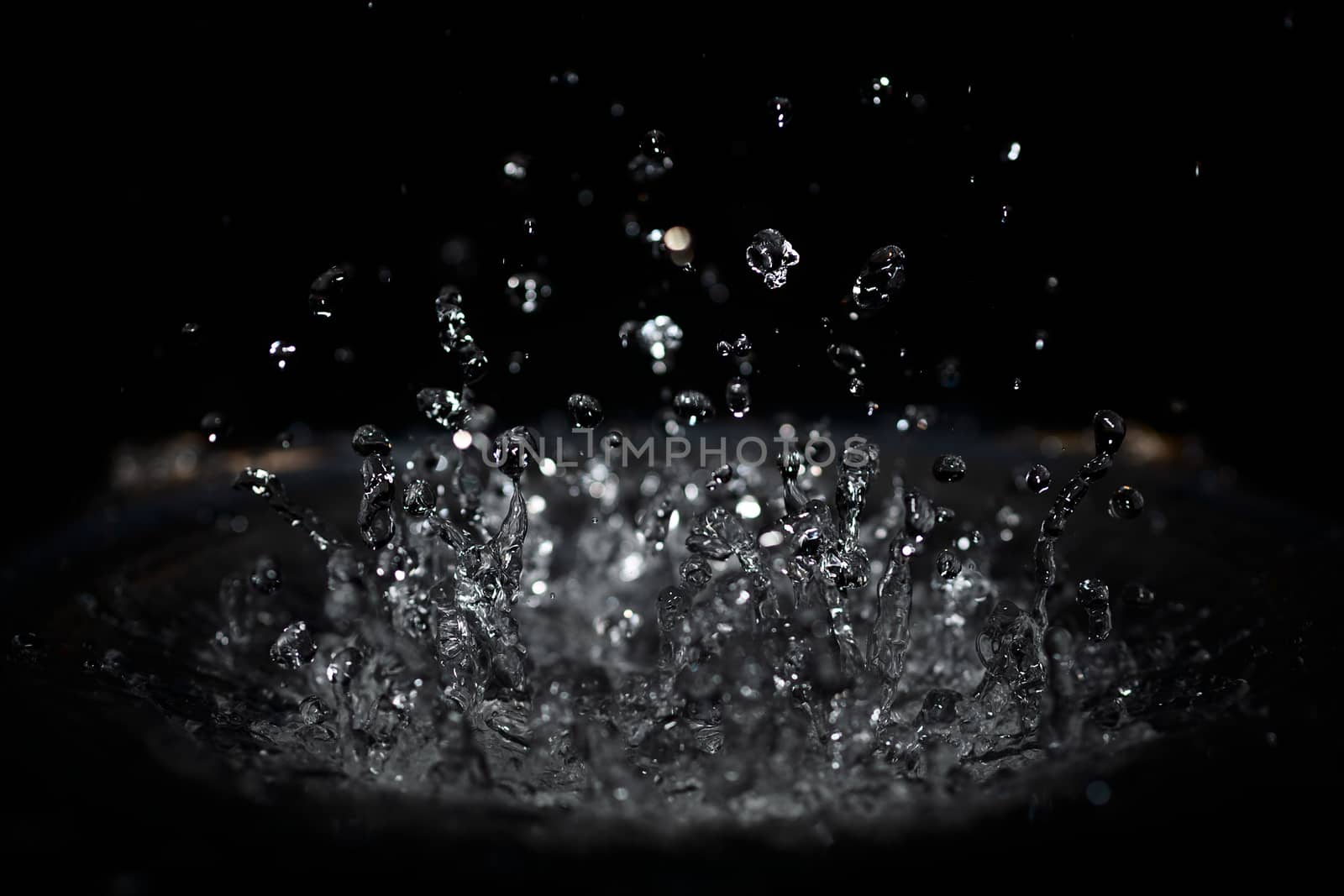 The splash of water drops in loudspeaker on black background. Pe by alexsdriver