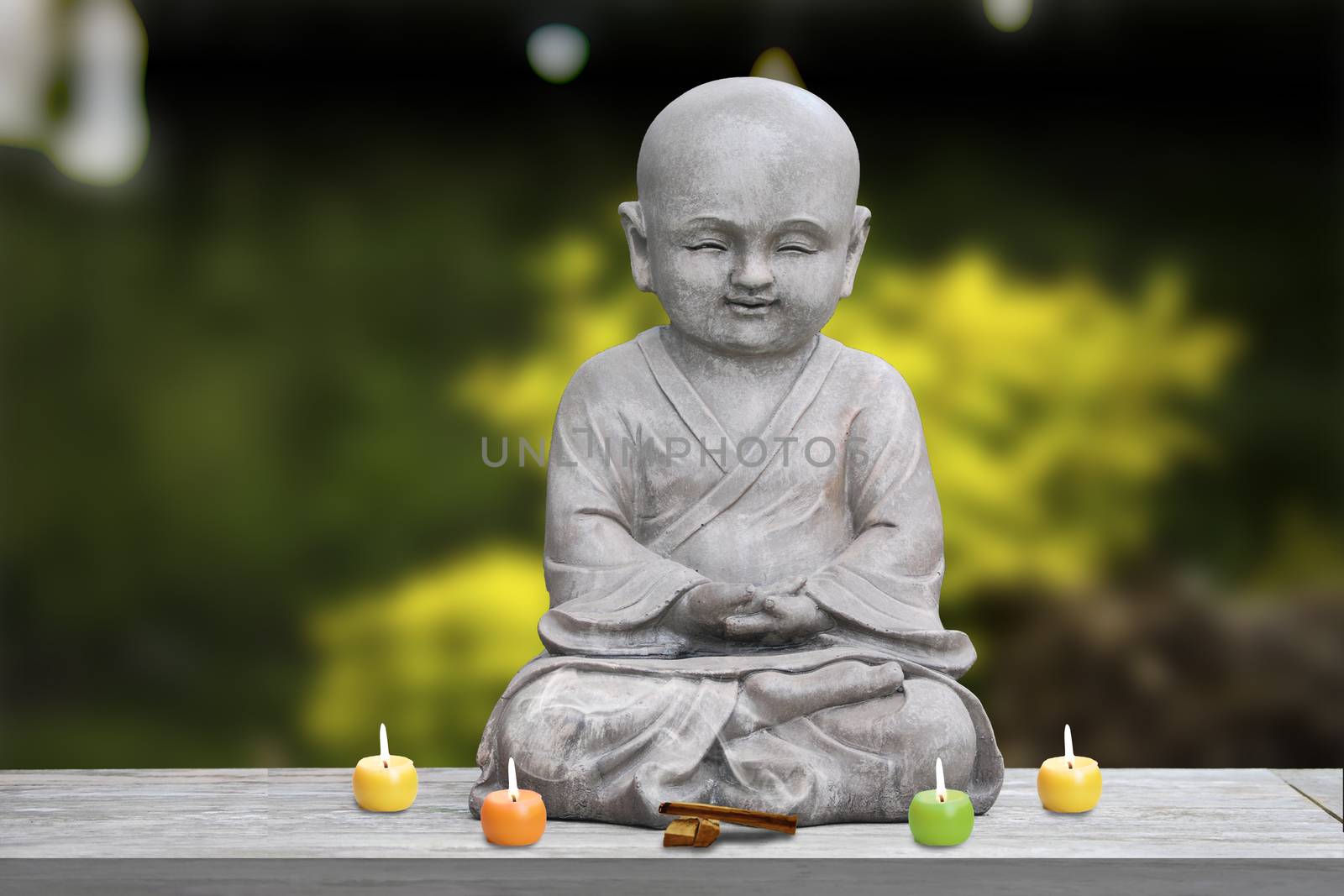 Buddha stone statue child background blur lit candles and incense