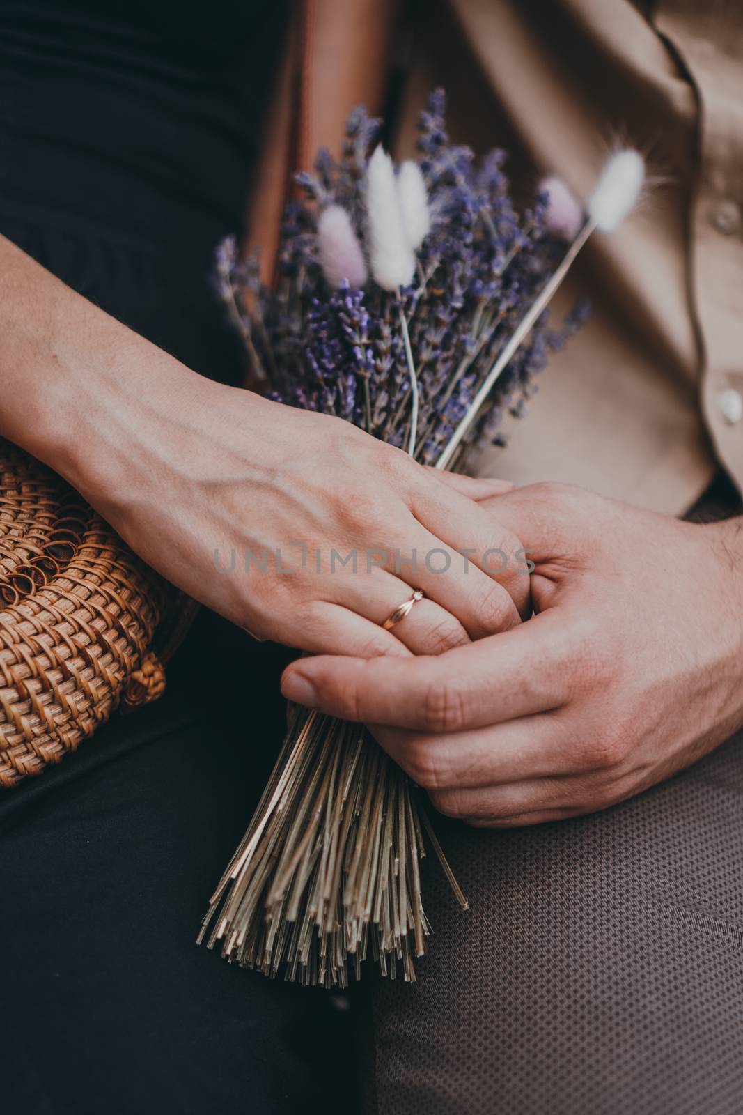 Bouquet of lavender flowers in girls hands. Engagement ring on hand. Love couple holding hands. Love, relationships, travel, romance concept.