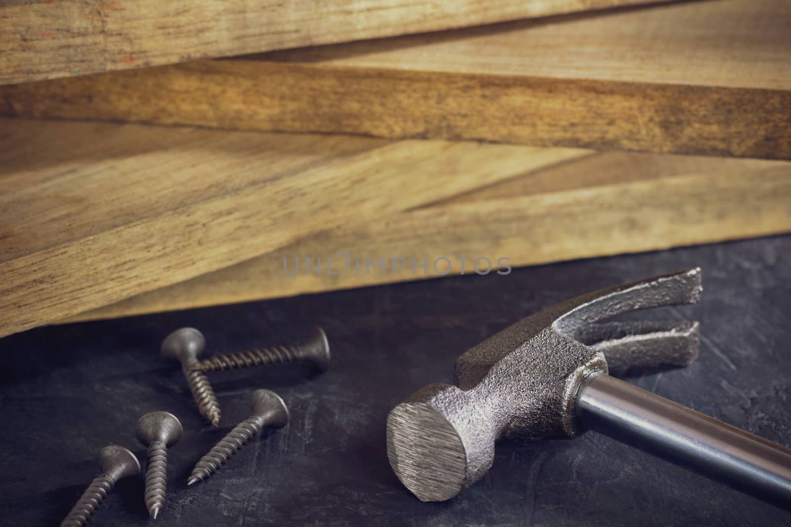 Close up hammer and screw in lumber stacking background. Copy sp by SaitanSainam