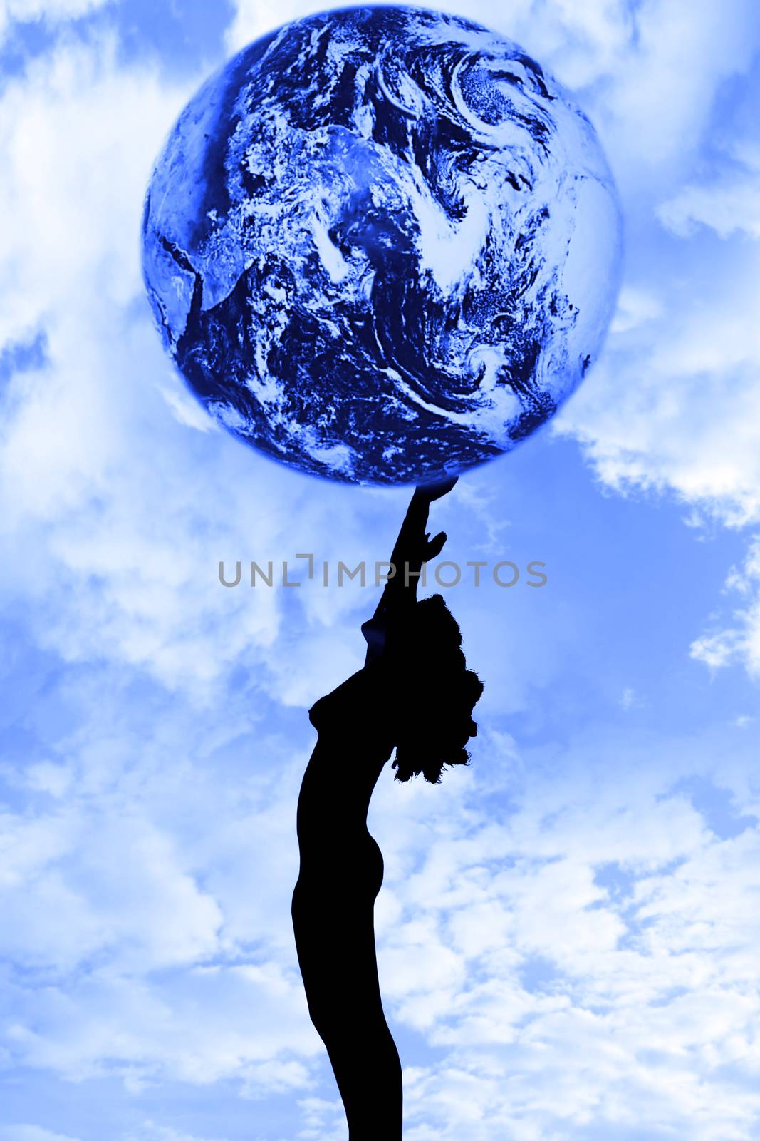 attractive silhouetted nude woman holding the earth giving gratitude to the heavens in a yoga pose with a cloudy background