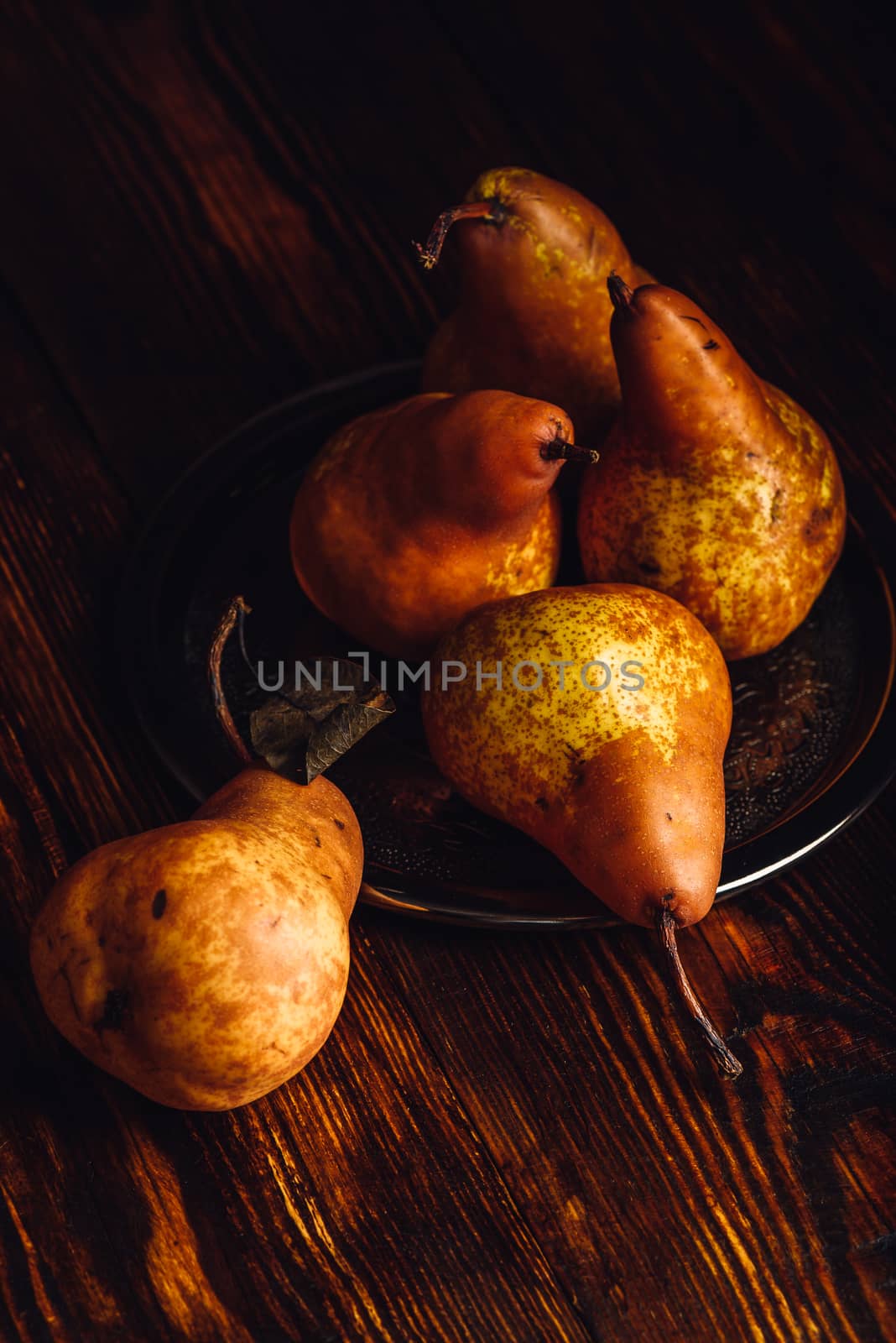 Few Golden Pears with Fork and Knife on Wooden Table. Vertical Orientation.