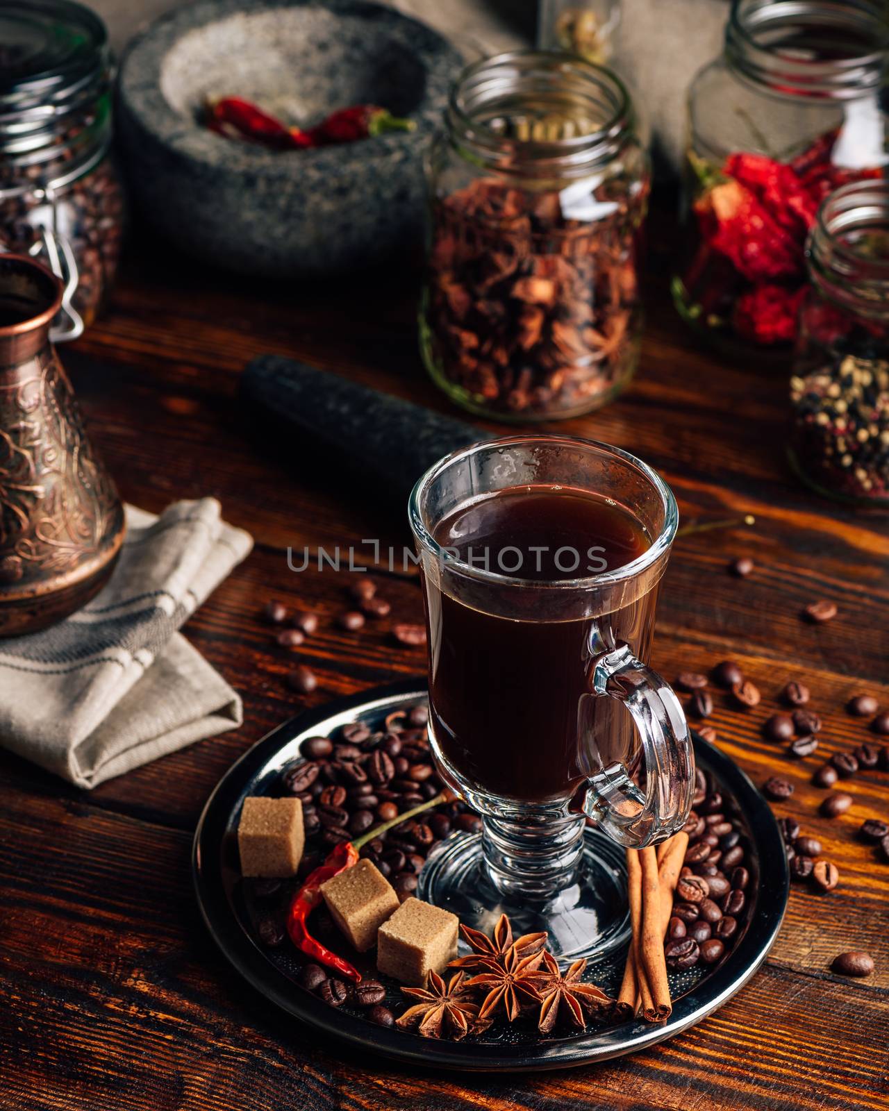 Cup of Coffee with Oriental Spices on Metal Tray. Cezve and Some Jars on Background.
