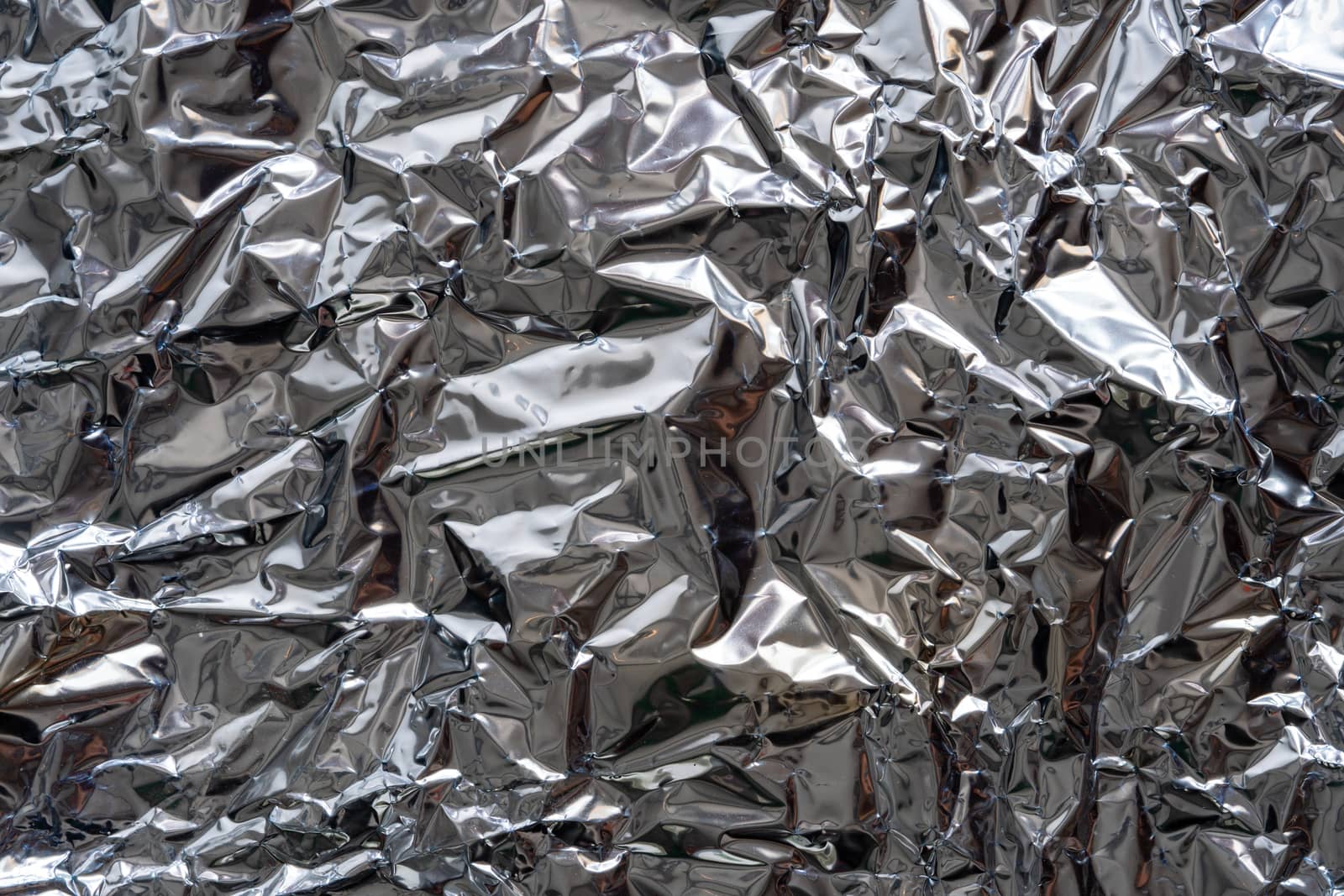 Texture of crumpled silver foil plastic. Concept of global warming.