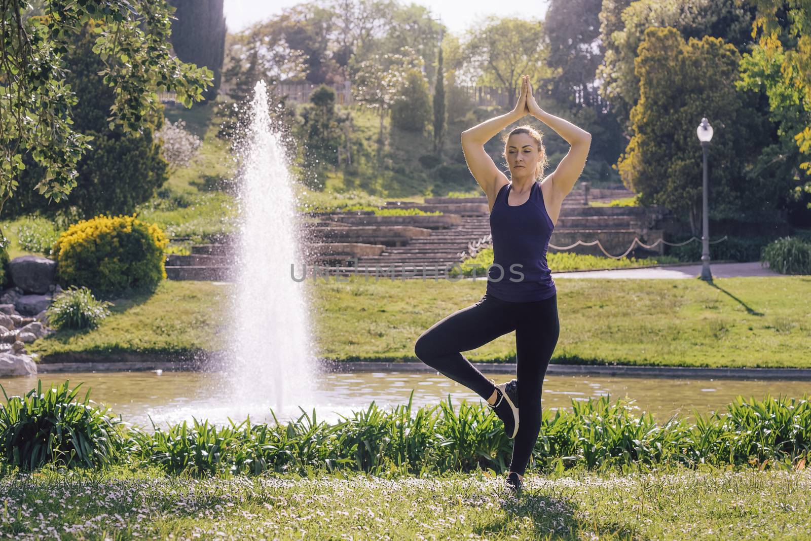 young sports woman doing meditation yoga exercises and relaxing outdoors in the park, modern healthy lifestyle and sport concept