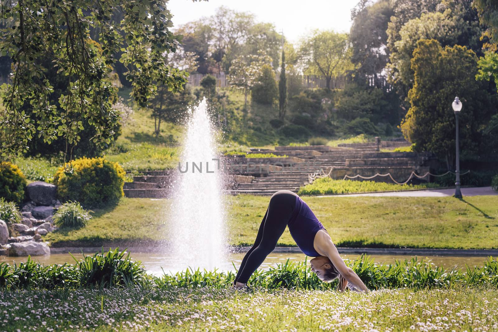 young sporty woman doing meditation yoga exercises and relaxing outdoors in the park, modern healthy lifestyle and sport concept
