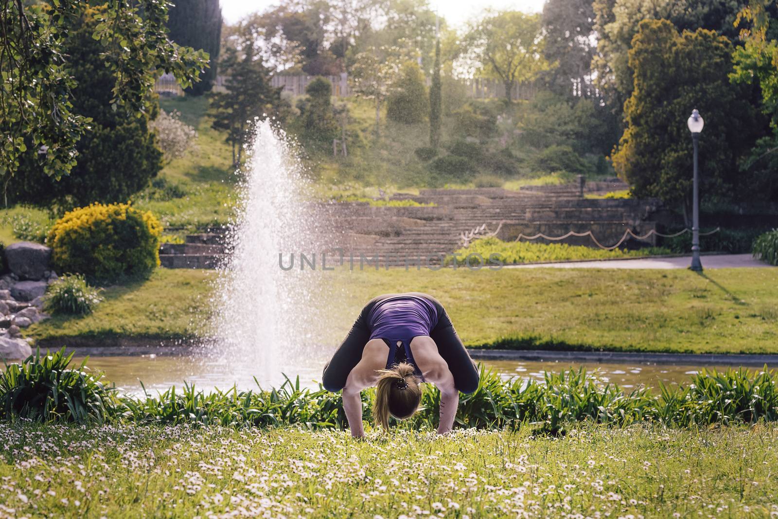 strong and young sports woman doing meditation yoga balancing exercises and relaxing outdoors in the park, modern healthy lifestyle and sport concept