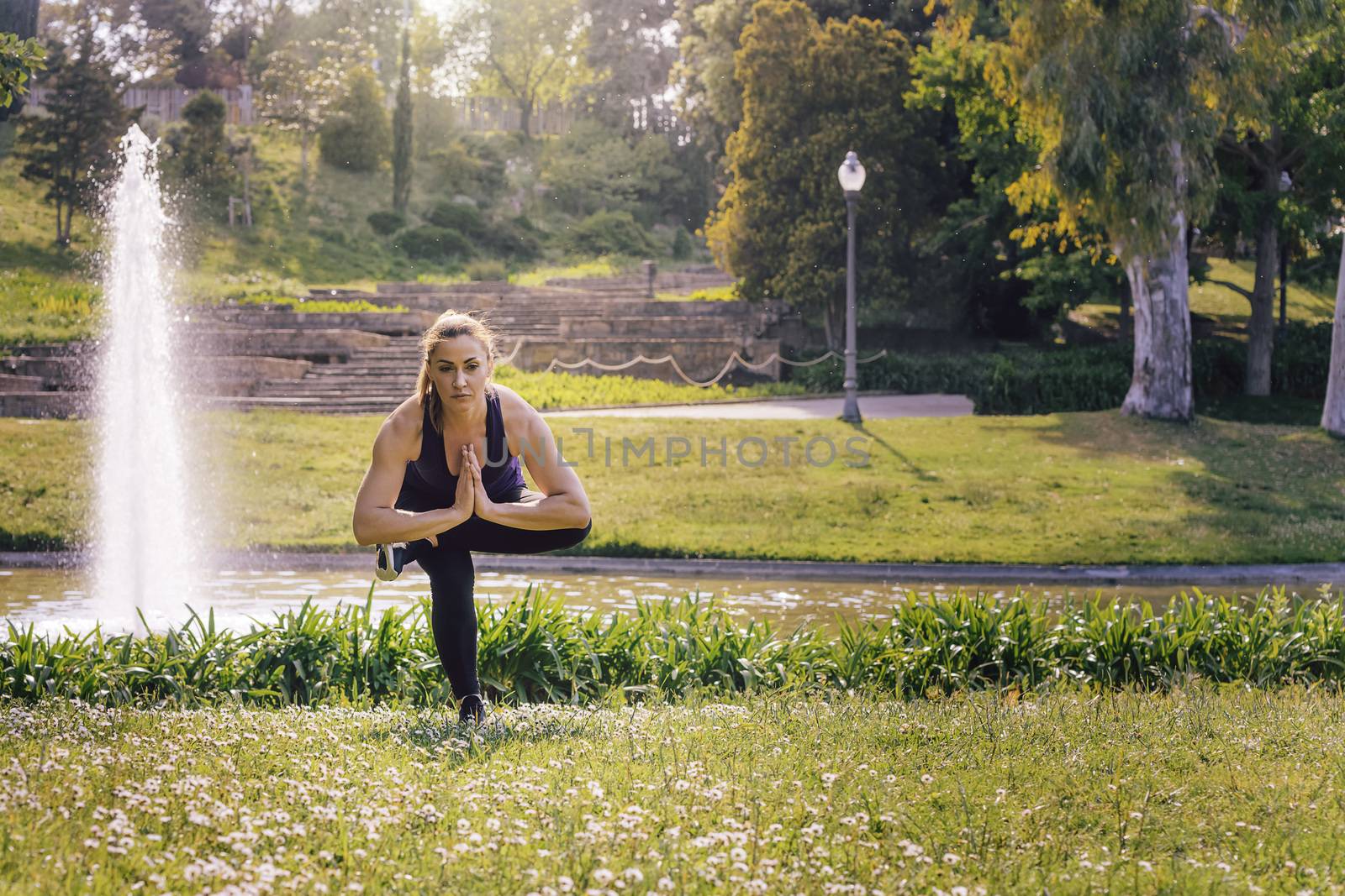 young sports woman doing meditation yoga balancing exercises and relaxing outdoors in the park, modern healthy lifestyle and sport concept